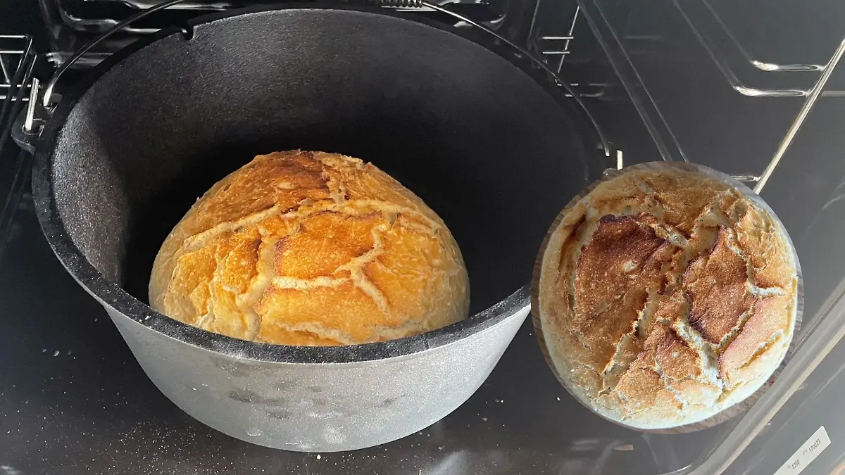 Dutch Oven steht auf dem Herd mit fertig gebackenem Brot. 