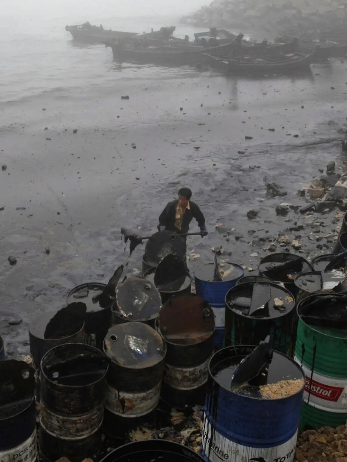A Greepeace handout photo released on 22 July 2010 shows local fishermen cleaning up oily sludge by from the contaminated beaches at Nanhaitun, Weitang Bay, China on 21 July 2010. The beach is where firefighter Zhang Liang lost his life fixing an underwater pump. Crude oil started pouring into the Yellow Sea off a busy northeastern port after a pipeline exploded late last week, sparking a massive 15-hour fire. The government says the slick has spread across a 70-square-mile (180-square-kilometer) stretch of ocean. EPA/JIANG HE / GREENPEACE / HANDOUT IMAGE AVAILABLE FOR DOWNLOAD BY EXTERNAL MEDIA FOR 14 DAYS AFTER RELEASE. TERMS OF HAND-OUT: NO RESALE, NO ARCHIVE, FOR EDITORIAL USE ONLY, NOT FOR MARKETING OR ADVERTISING CAMPAIGNS. EDITORIAL USE ONLY