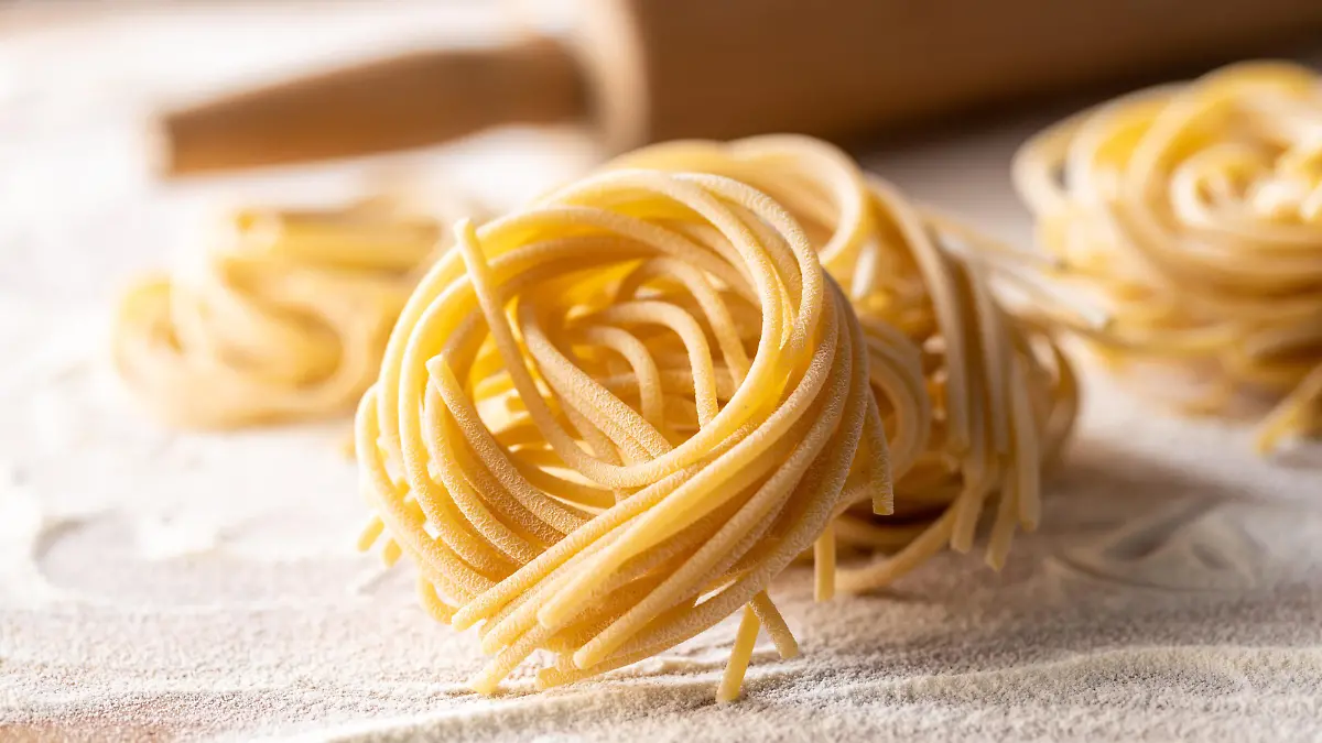 Italian pasta nest. Uncooked spaghetti nest and flour.