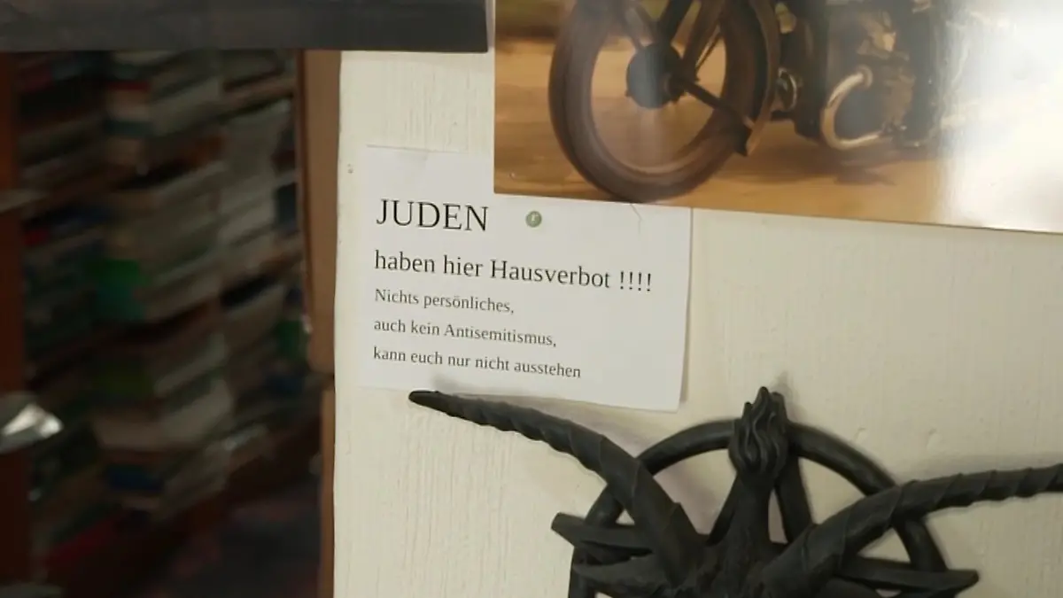 Trotz Aufforderung der Polizei den Zettel abzumachen, hängt der Ladenbesitzer ihn drinne wieder auf.