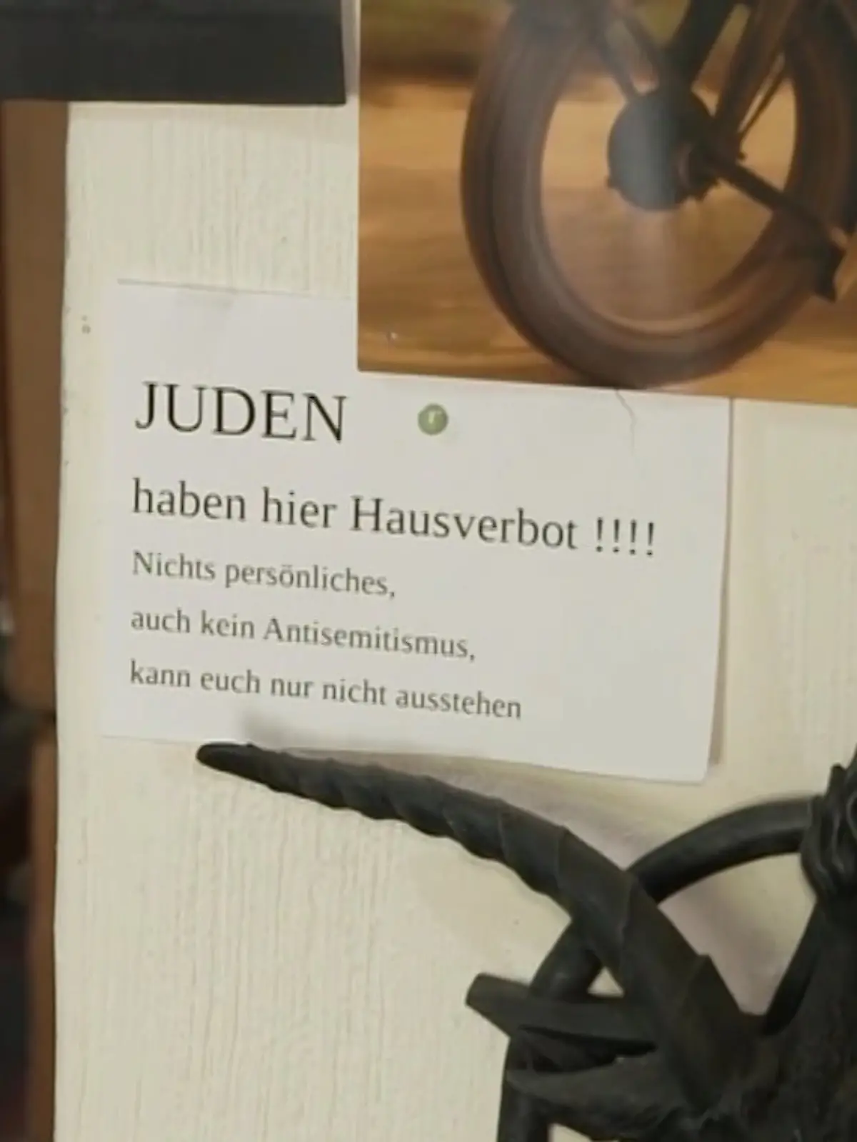 Trotz Aufforderung der Polizei den Zettel abzumachen, hängt der Ladenbesitzer ihn drinne wieder auf.