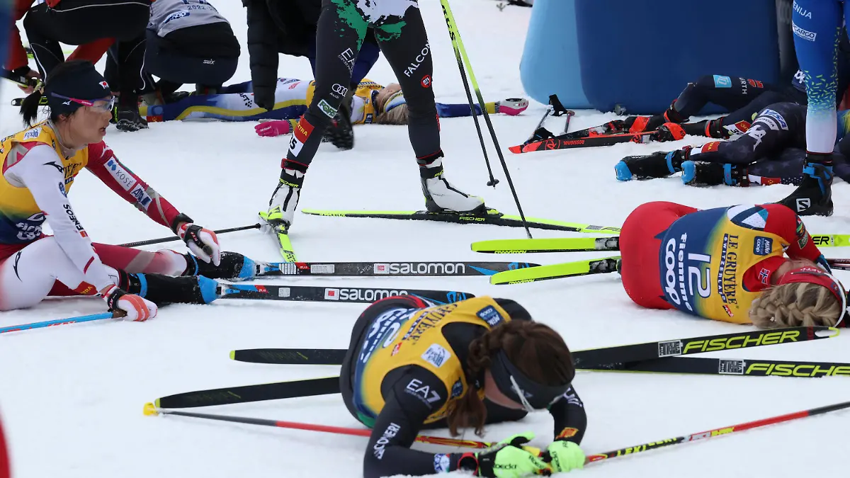 Sweden's Frida Karlsson, top, lies on the snow at the end of the Women's Mass Start 10km of the Tour de Ski cross country event in Val di Fiemme, Trento, Italy, Sunday, Jan. 8, 2023. (AP Photo/Alessandro Trovati)