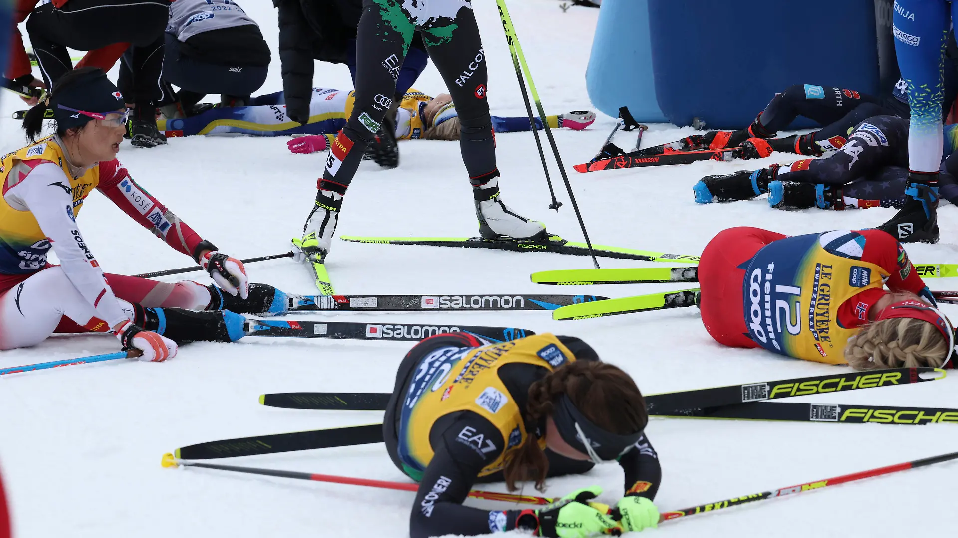 Sweden's Frida Karlsson, top, lies on the snow at the end of the Women's Mass Start 10km of the Tour de Ski cross country event in Val di Fiemme, Trento, Italy, Sunday, Jan. 8, 2023. (AP Photo/Alessandro Trovati)
