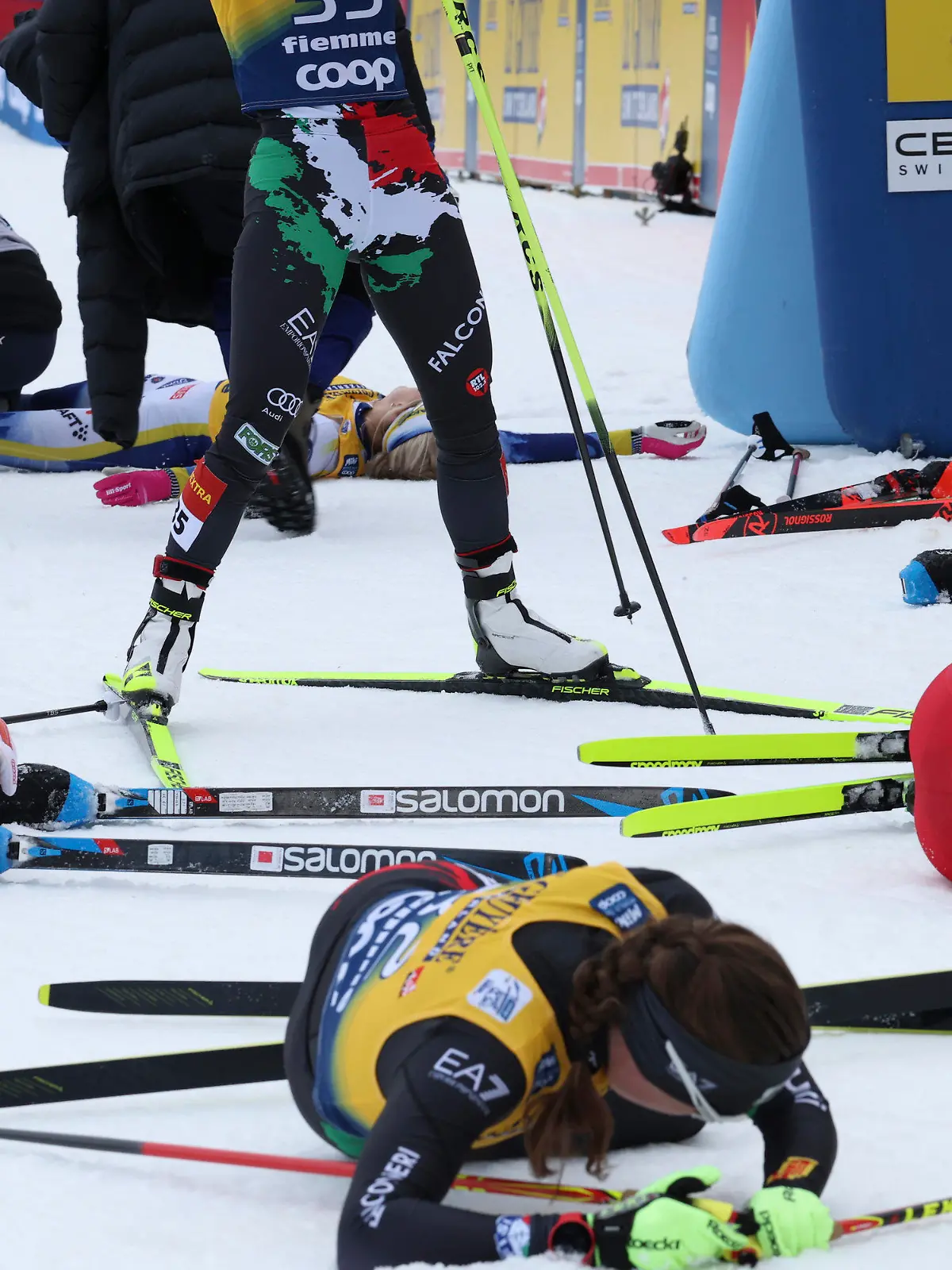 Sweden's Frida Karlsson, top, lies on the snow at the end of the Women's Mass Start 10km of the Tour de Ski cross country event in Val di Fiemme, Trento, Italy, Sunday, Jan. 8, 2023. (AP Photo/Alessandro Trovati)
