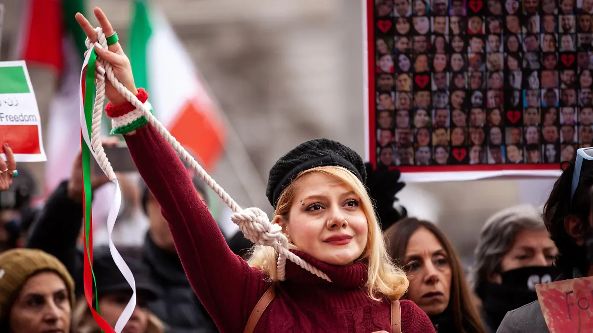 A woman wears a noose and ribbons to protest teh execution of Mohsen Shekari by the Islamic regime in Iran at a protest on International Human RIghts Day. Demonstrators demanded justice for Shekari, a 23-year-old man executed December 8 for allegedly blocking a street and injuring a soldier during a protest. (Photo by Allison Bailey/NurPhoto)