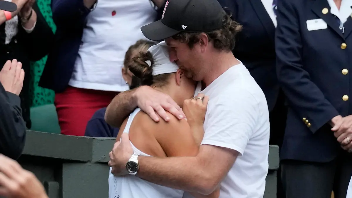 Australia's Ashleigh Barty hugs her boyfriend Gary Kissick in the players box as she celebrates after defeating reacts after defeating the Czech Republic's Karolina Pliskova in the women's singles final on day twelve of the Wimbledon Tennis Championships in London, Saturday, July 10, 2021. (Pete Nichols/Pool Via AP)