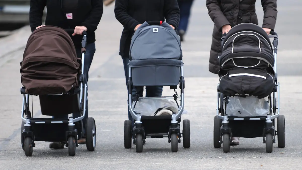 ARCHIV - Drei Frauen schieben am 19.11.2009 ihre Kinderwagen über die Strandpromenade des Ostseebads Travemünde. Bundesfamilienministerin Schwesig (SPD) stellt am 21.03.2014 in Berlin Details zum Elterngeld Plus vor. Foto: Marcus Brandt/dpa +++(c) dpa - Bildfunk+++