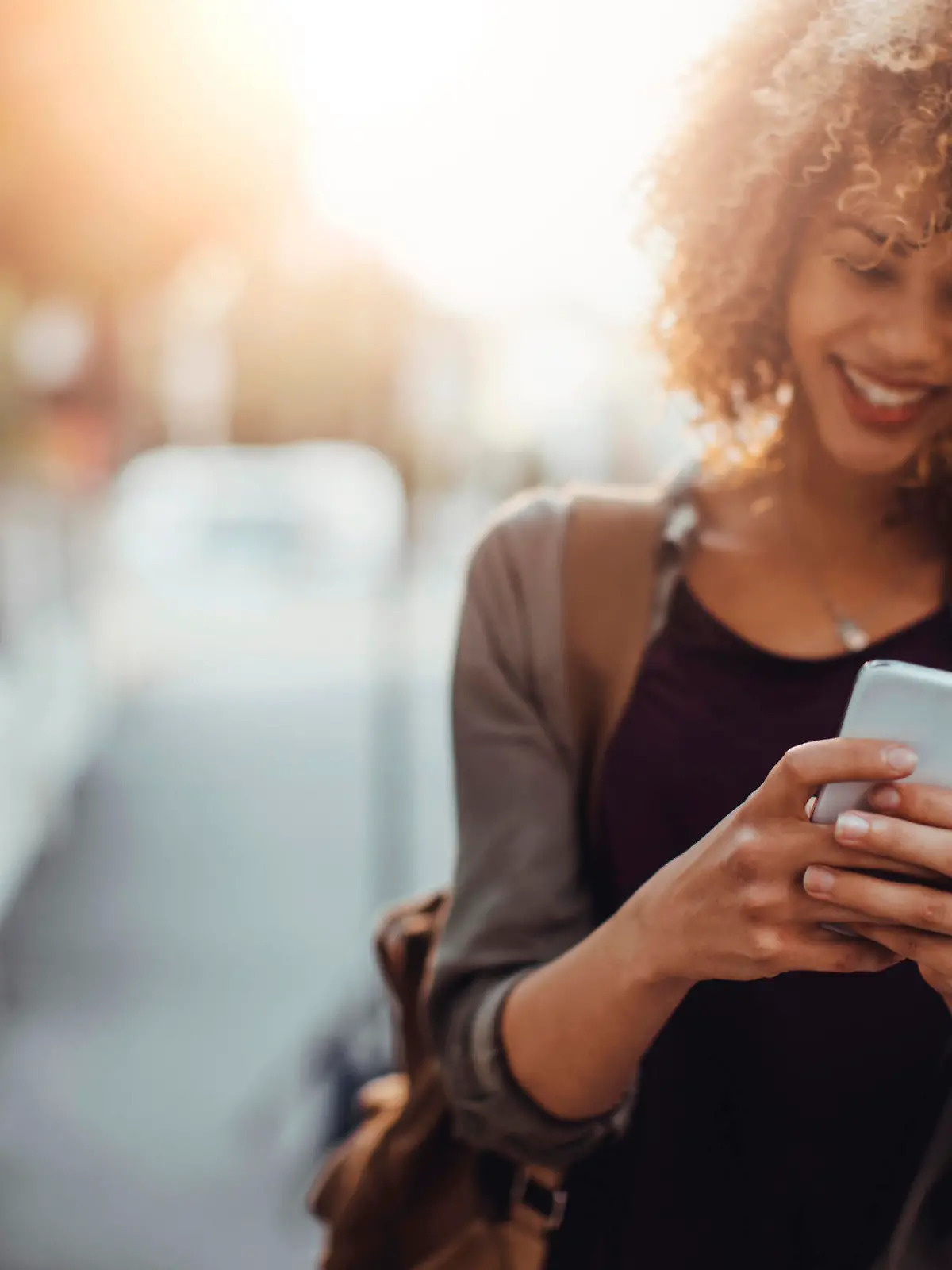 Picture of a young smiling woman using a phone