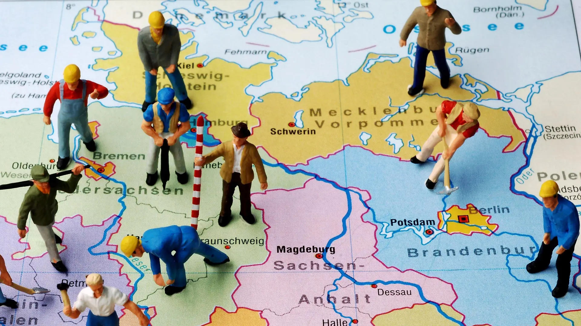 ARCHIV - Illustration - Kleine Plastikfiguren stehen auf einer Landkarte von Deutschland verteilt auf die Bundesländer - gerade ein Drittel der Figuren stehen auf der ostdeutschen Kartenseite (Illustrationsfoto vom 07.11.2005). Die Zahl der Erwerbsbevölkerung im Osten schrumpft - die Menschen ziehen verstärkt in die alten Bundesländer, wo es Arbeit gibt. Mehr als 3,8 Millionen Ostdeutsche packten in den 20 Jahren der deutsche Einheit die Koffer, vor allem auf der Suche nach Arbeit. Foto: Jens Büttnerzu dpa-Themenpaket Tag der Einheit vom 30.09.2010 / Wiederholung vom 23.09.2010 - +++(c) dpa - Bildfunk+++