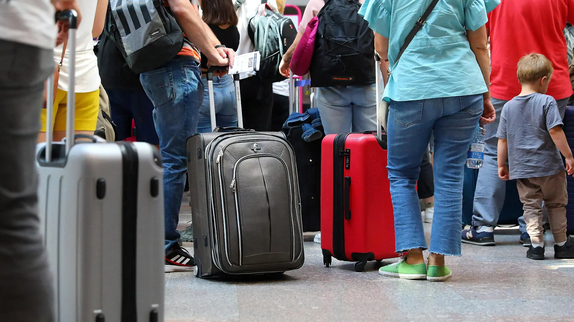 Passagiere checken ihre Koffer ein und müssen warten. Das Reiseaufkommen in diesem Sommer an den internationalen Flughäfen ist hoch.