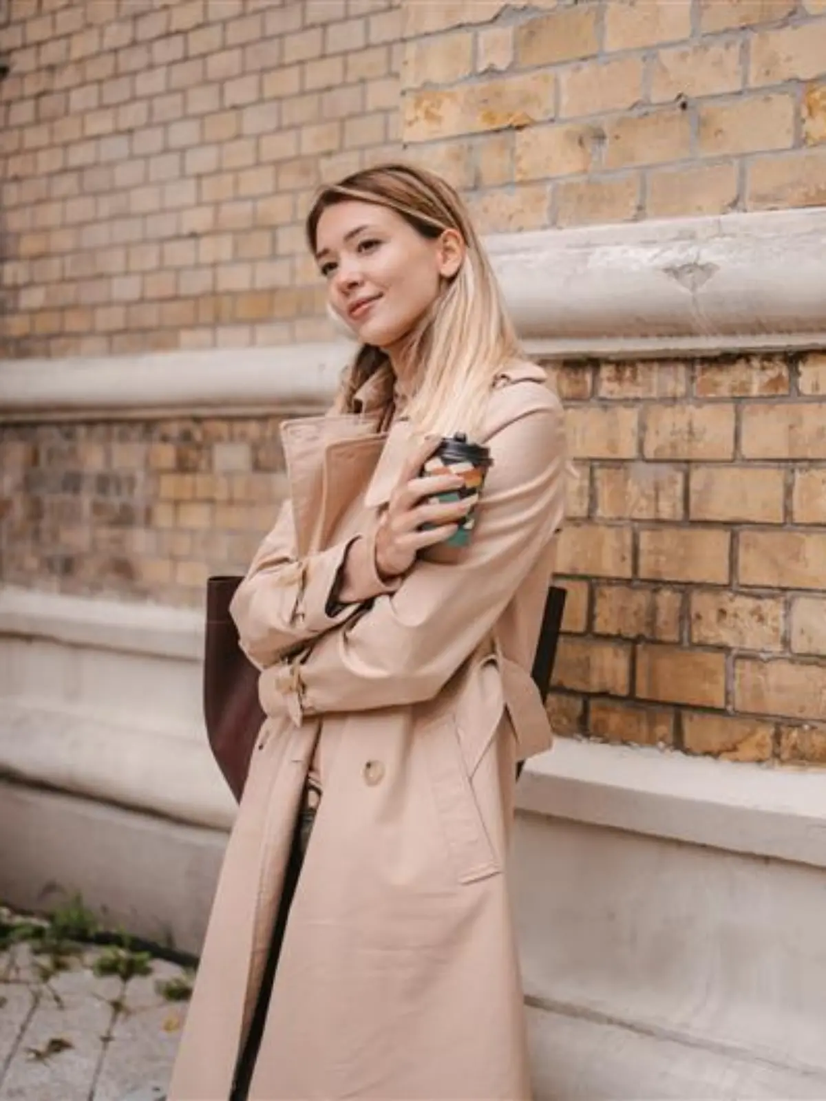 Frau trägt einen Trenchcoat.