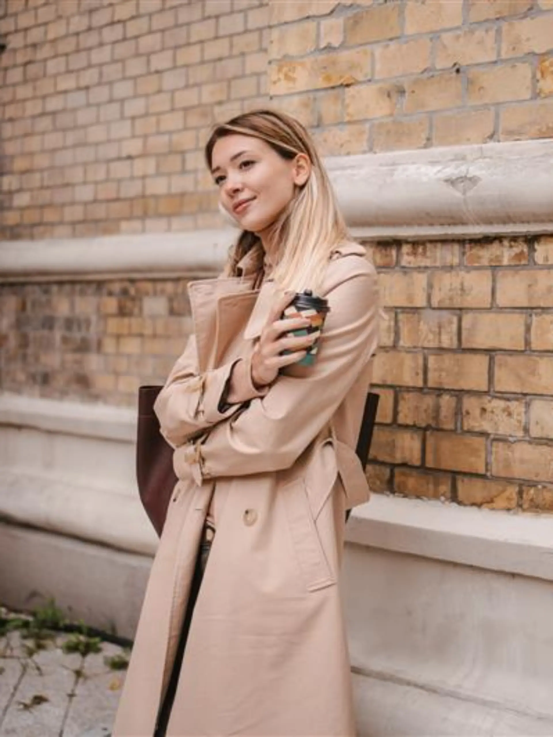 Frau trägt einen Trenchcoat.