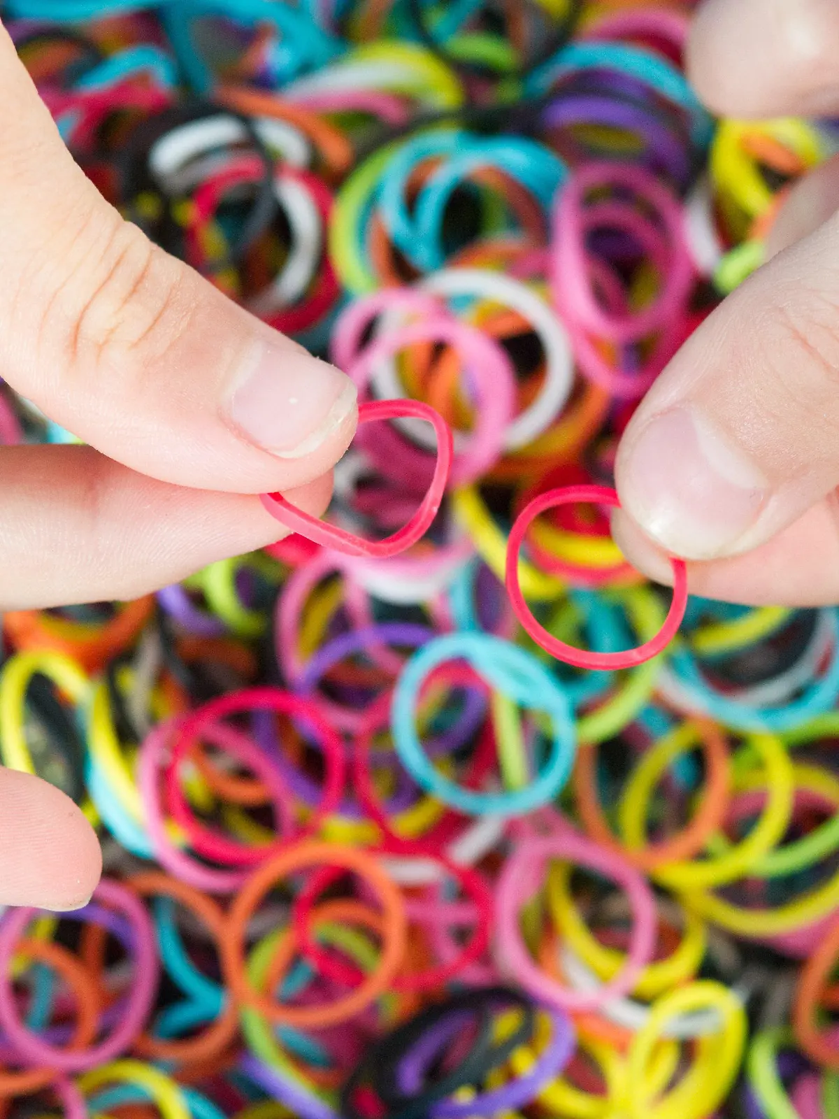 ILLUSTRATION - Ein Kind hält am 04.08.2014 in München (Bayern) Gummiringe, sogenannte Loom Bands. Das Flechten von Armbändern und anderem Schmuck aus Gummiringen - den Loom Bands - ist mittlerweile auch in Deutschland ein Trend. Foto: Tobias Hase/dpa (zu dpa «Rainbow Looms: Ein neuer Trend und seine Gefahren» vom 09.08.2014) +++(c) dpa - Bildfunk+++