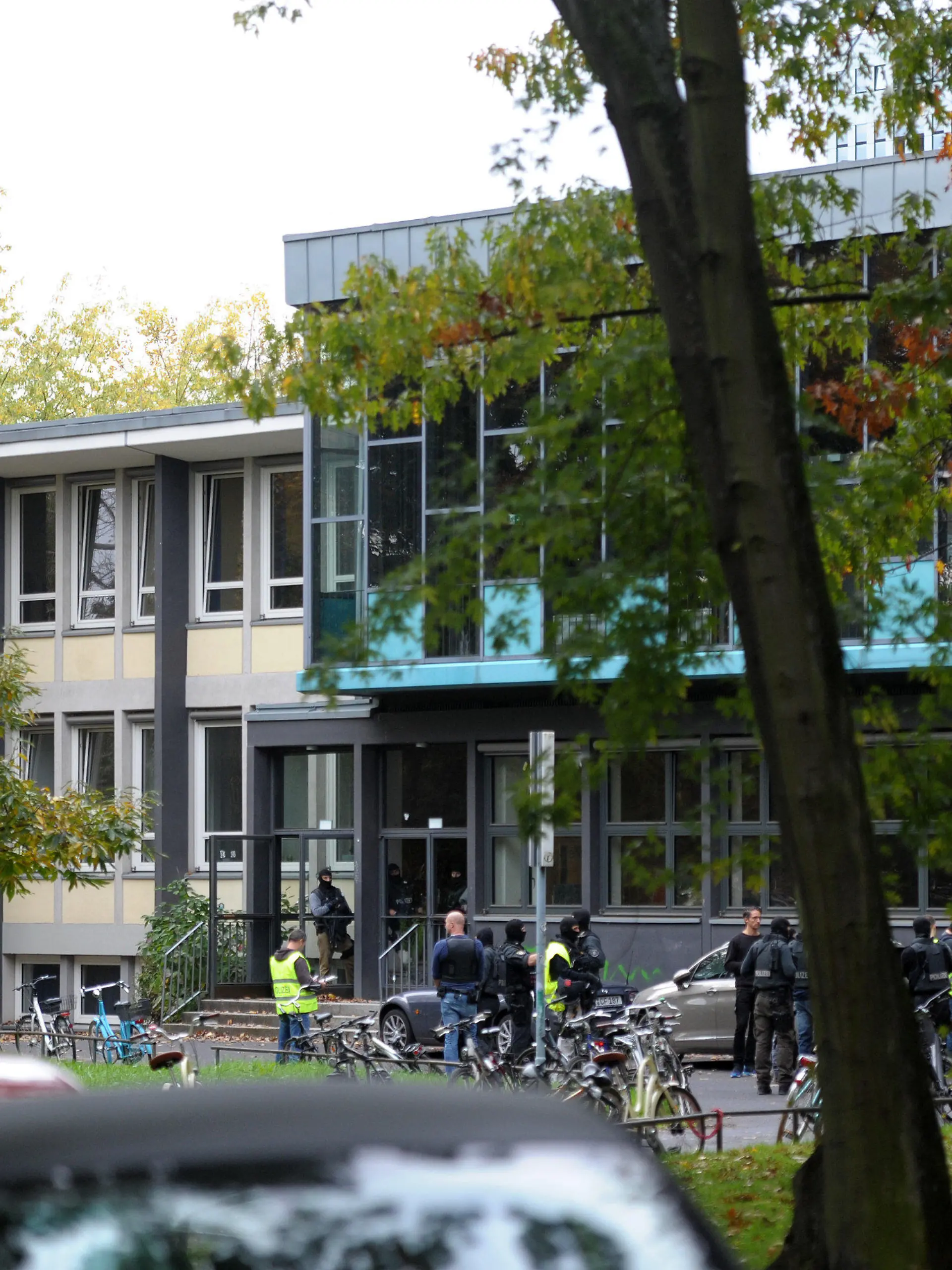 Beamte eines Spezialeinsatzkommandos (SEK) der Polizei stehen am 20.10.2014 vor einer Schule in Köln (Nordrhein-Westfalen). Nach Angaben eines Polizeisprechers am Einsatzort hatten Schüler berichtet, ein Mann habe einen Gegenstand in der Hand gehabt, der wie eine Waffe aussehe. Ein Spezialeinsatzkommando durchsuchte die Schule. Foto: Marius Becker/dpa +++(c) dpa - Bildfunk+++
