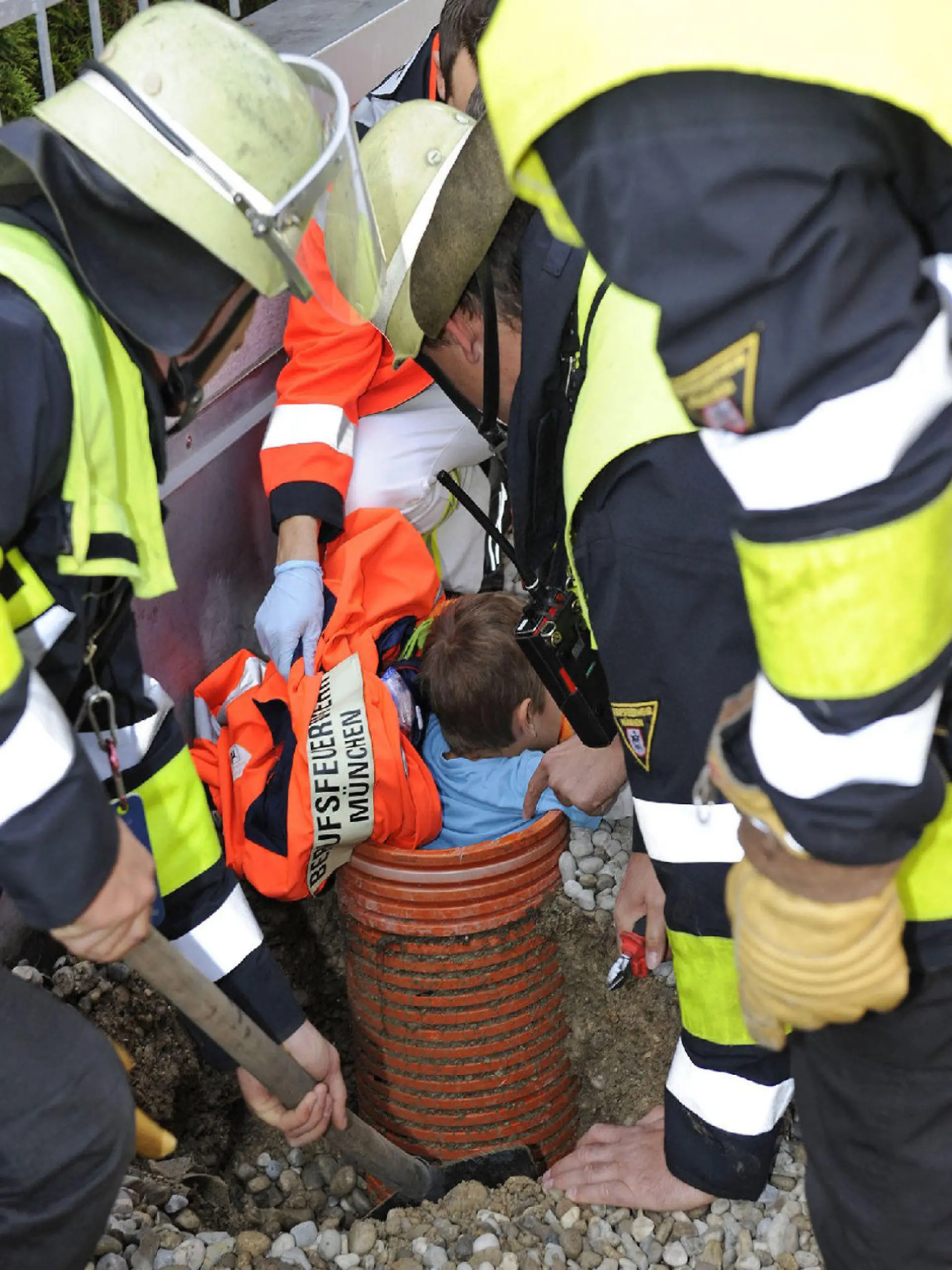HANDOUT - Feuerwehrleute befreien am 18.10.2014 in München einen Fünfjährigen, der beim Spielen in einem Rohr stecken geblieben war. Er überstand sein Abenteuer ohne Verletzungen, wie die Branddirektion am 19.10.2014 mitteilte. Foto: Branddirektion München/dpa (zu dpa «Feuerwehr befreit Kind aus Rohr» vom 19.10.2014 - ACHTUNG: Verwendung nur für redaktionelle Zwecke im Zusammenhang mit der Berichterstattung über die Rettungsaktion und nur bei Urheber-Nennung Foto: Branddirektion München) +++(c) dpa - Bildfunk+++