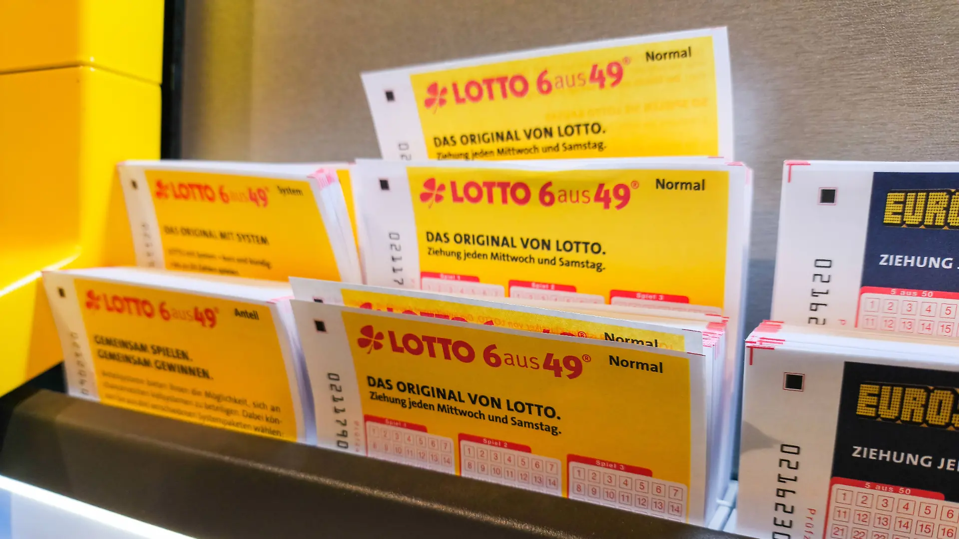 Mehrere Lotto- und Eurojackpot-Spielscheine in einer Auslage, 2025
