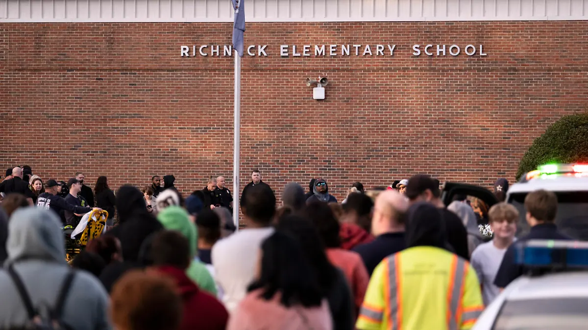 Students and police gather outside of Richneck Elementary School after a shooting, Friday, Jan. 6, 2023 in Newport News, Va. A shooting at a Virginia elementary school sent a teacher to the hospital and ended with “an individual” in custody Friday, police and school officials in the city of Newport News said. (Billy Schuerman/The Virginian-Pilot via AP)