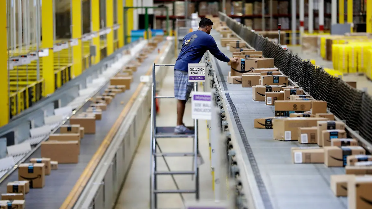 FILE - In this Tuesday, Aug. 1, 2017, photo, an Amazon employee makes sure a box riding on a belt is not sticking out at the Amazon Fulfillment center in Robbinsville Township, N.J. Amazon failed to properly record work-related injuries at warehouses located in five states, a federal agency said Friday, Dec. 16, 2022, while announcing it issued more than a dozen citations during the course of its ongoing investigation of the company. (AP Photo/Julio Cortez, File)