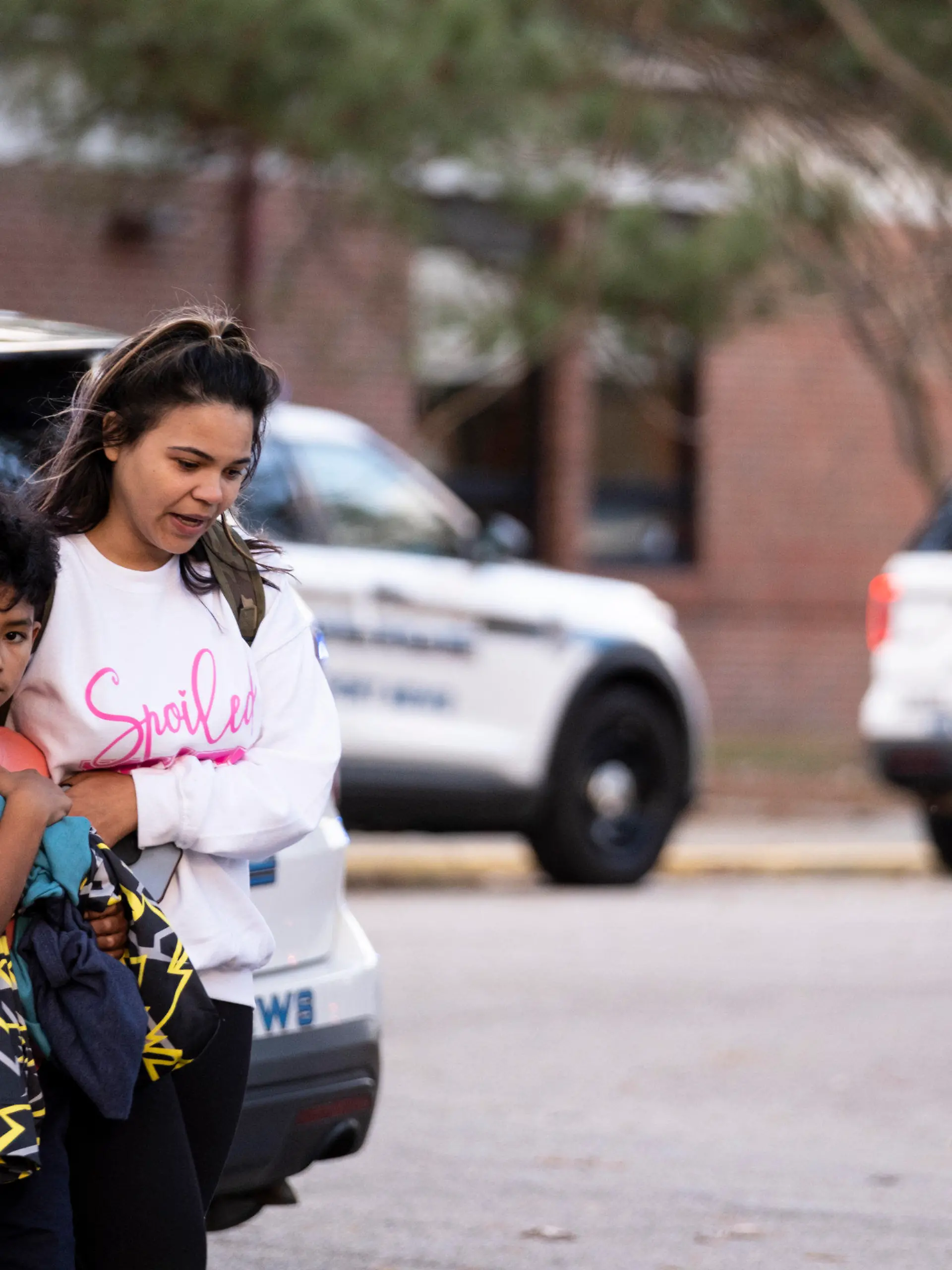 Carlos Glover, age 9,  a fourth grader at Richneck Elementary School, is held by his mother Joselin Glover as they leave the school, Friday, Jan. 6, 2023 in Newport News, Va. A shooting at a Virginia elementary school sent a teacher to the hospital and ended with “an individual” in custody Friday, police and school officials in the city of Newport News said. (Billy Schuerman/The Virginian-Pilot via AP)