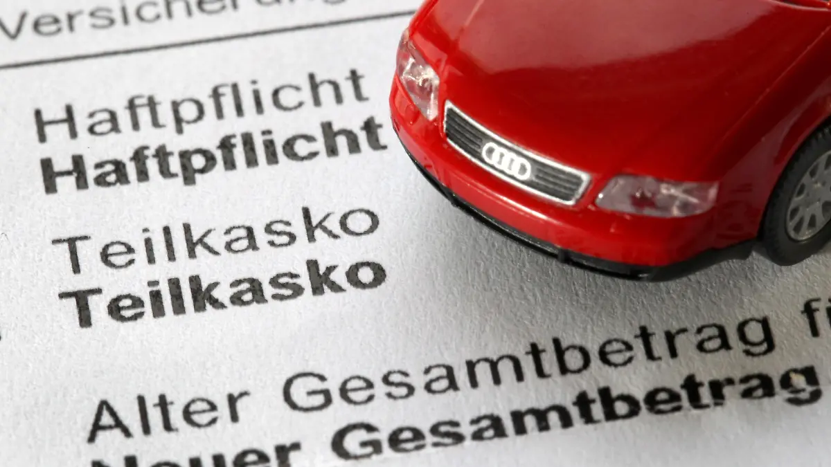 ILLUSTRATION - Ein Modellauto steht am Donnerstag (18.11.2010) auf einer Mitteilung eines Autoversicherers zu neuen Beiträgen. Viele Autofahrer bezahlen zu viel Geld für ihre Autoversicherung. Foto: Martin Gerten/dpa +++(c) dpa - Bildfunk+++