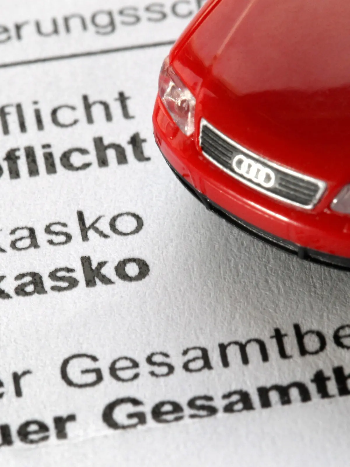 ILLUSTRATION - Ein Modellauto steht am Donnerstag (18.11.2010) auf einer Mitteilung eines Autoversicherers zu neuen Beiträgen. Viele Autofahrer bezahlen zu viel Geld für ihre Autoversicherung. Foto: Martin Gerten/dpa  +++(c) dpa - Bildfunk+++