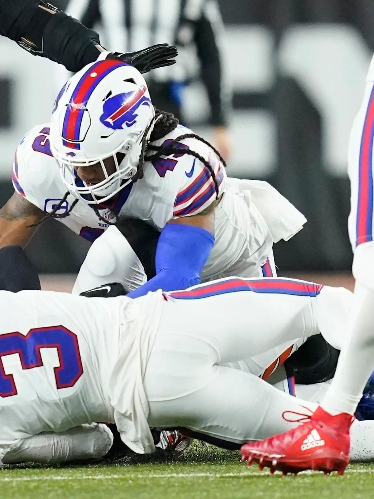 Buffalo Bills safety Damar Hamlin (3) lies on the turf after making a tackle on Cincinnati Bengals wide receiver Tee Higgins, blocked from view, as Buffalo Bills linebacker Tremaine Edmunds (49) assists at the end of the play during the first half of an NFL football game between the Cincinnati Bengals and the Buffalo Bills, Monday, Jan. 2, 2023, in Cincinnati. After getting up from the play, Hamlin collapsed and was administered CPR on the field. (AP Photo/Joshua A. Bickel)