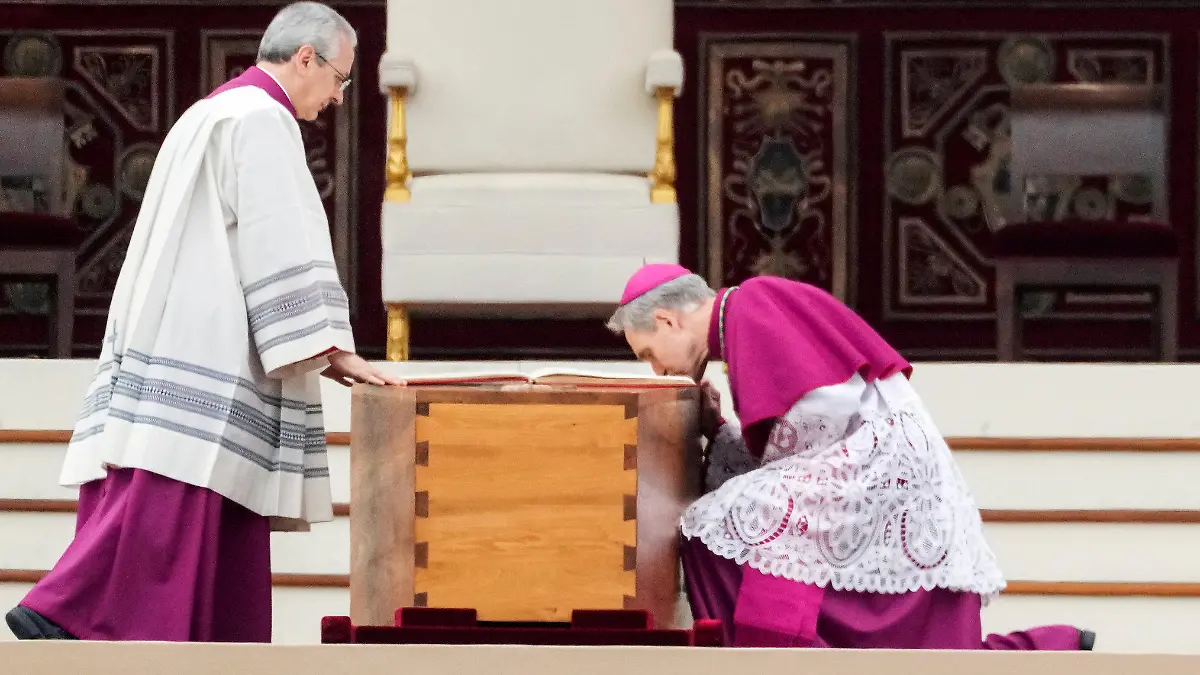 05.01.2023, Vatikan, Vatikanstadt: Georg Gänswein (r), Kurienerzbischof und langjähriger Privatsekretär des verstorbenen emeritierten Papst Benedikt XVI., kniet am Sarg des verstorbenen emeritierten Papstes Benedikt XVI. vor Beginn der Trauermesse auf dem Petersplatz. Der emeritierte Papst Benedikt XVI. starb am 31.12.2022 im Alter von 95 Jahren im Vatikan. Foto: Alessandra Tarantino/AP/dpa +++ dpa-Bildfunk +++
