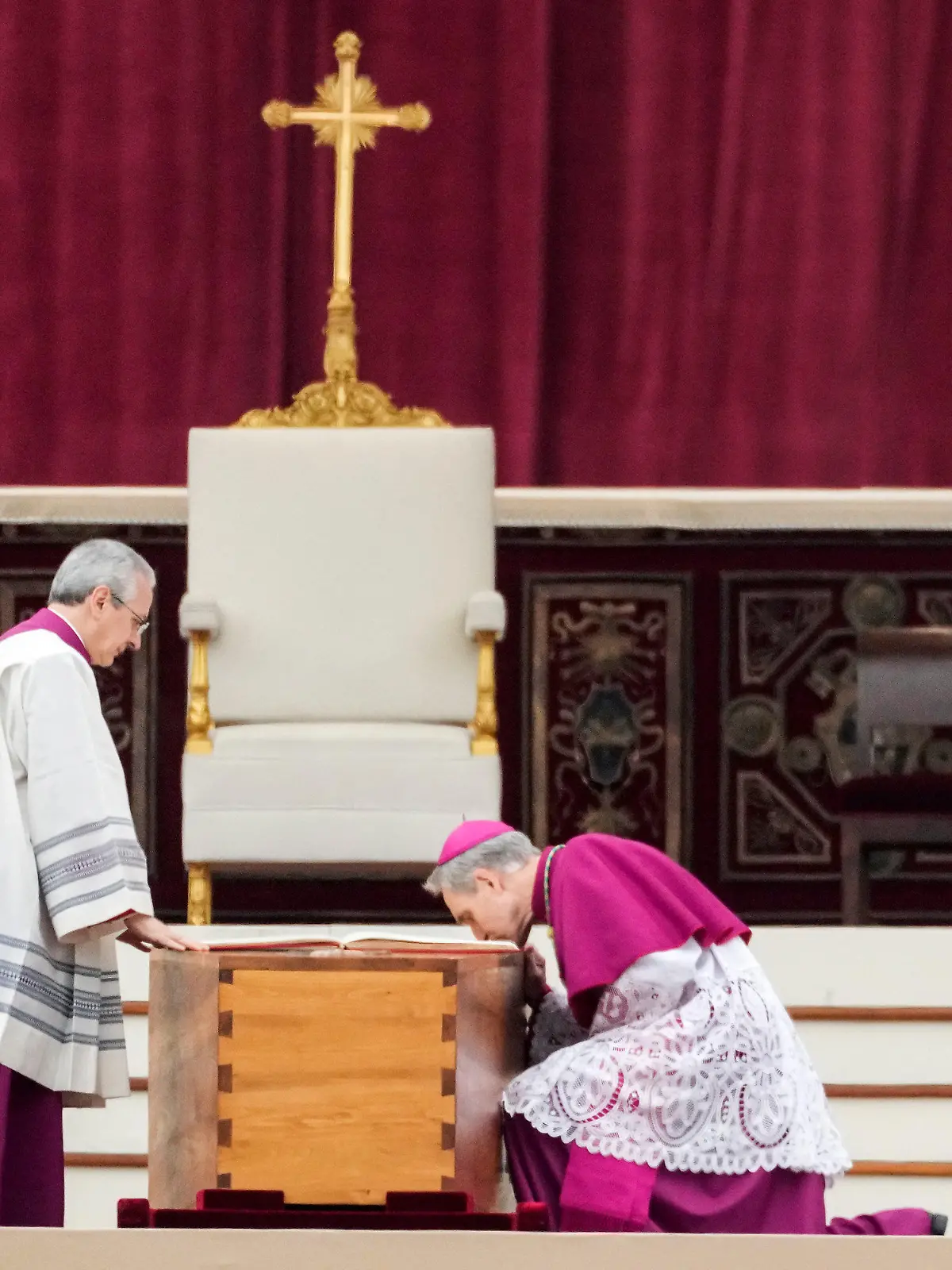 05.01.2023, Vatikan, Vatikanstadt: Georg Gänswein (r), Kurienerzbischof und langjähriger Privatsekretär des verstorbenen emeritierten Papst Benedikt XVI., kniet am Sarg des verstorbenen emeritierten Papstes Benedikt XVI. vor Beginn der Trauermesse auf dem Petersplatz. Der emeritierte Papst Benedikt XVI. starb am 31.12.2022 im Alter von 95 Jahren im Vatikan. Foto: Alessandra Tarantino/AP/dpa +++ dpa-Bildfunk +++