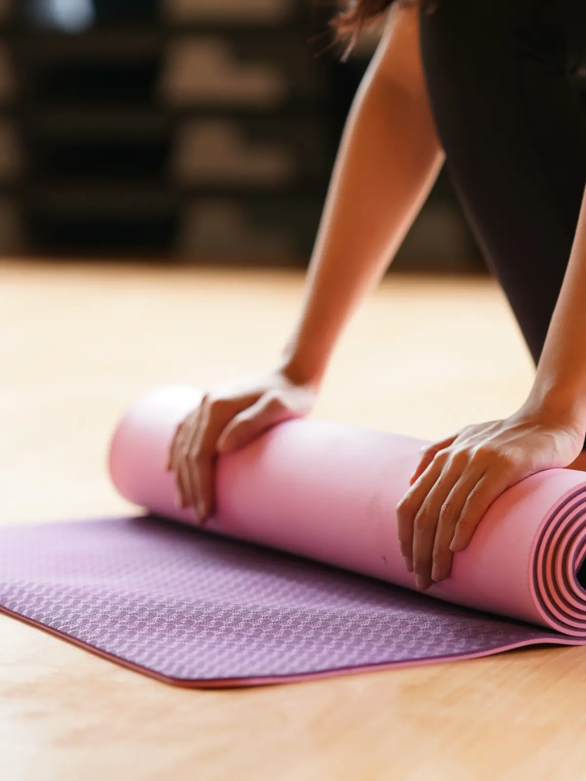 Yogamatte wird gerade eingerollt. 