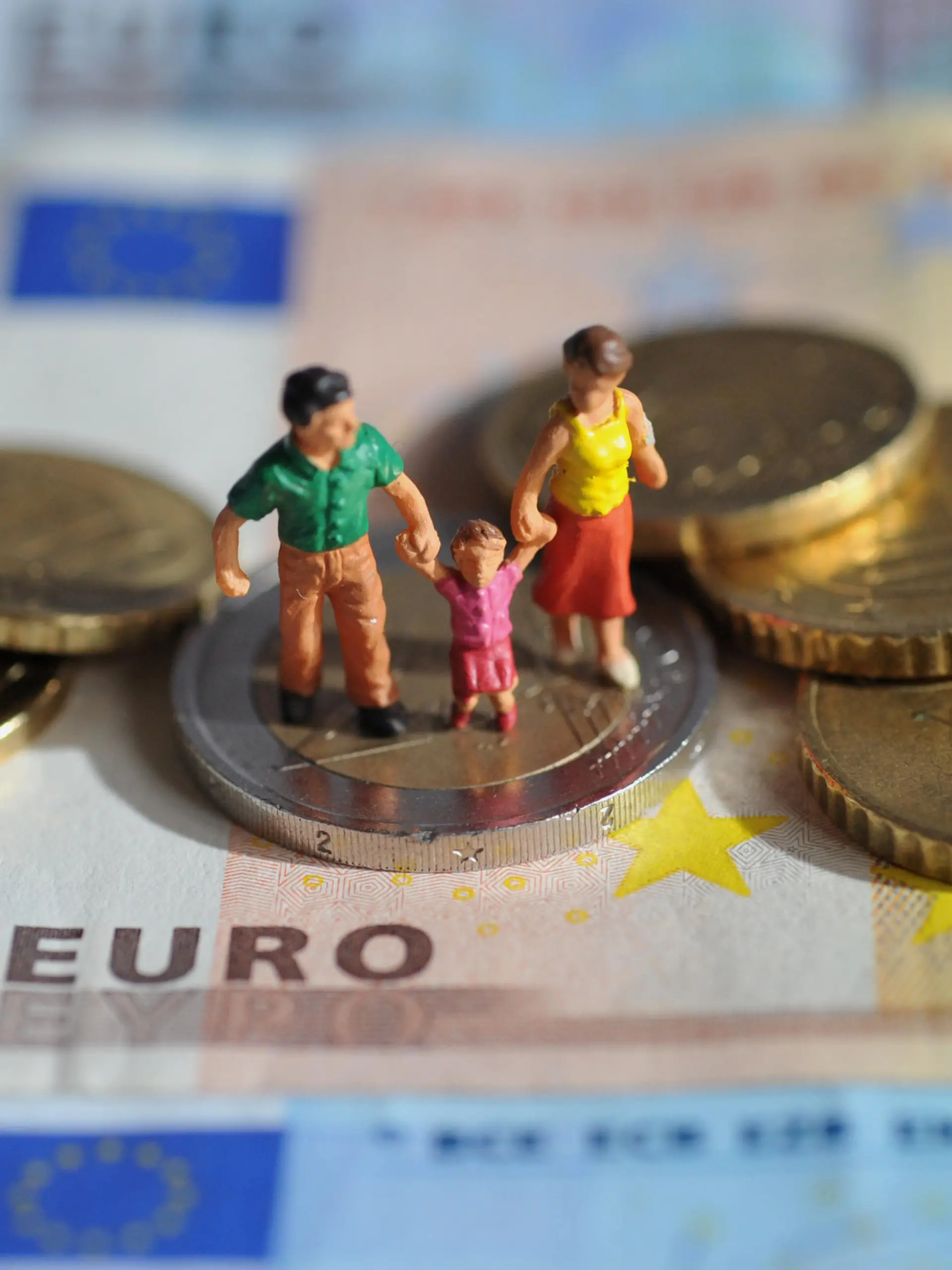 ILLUSTRATION - Ein Paar mit einem Kind steht auf einer Zwei-Euro-Münze, die auf einem 50-Euro-Schein liegt, aufgenommen am 16.02.2011. Foto: Andreas Gebert dpa/lby