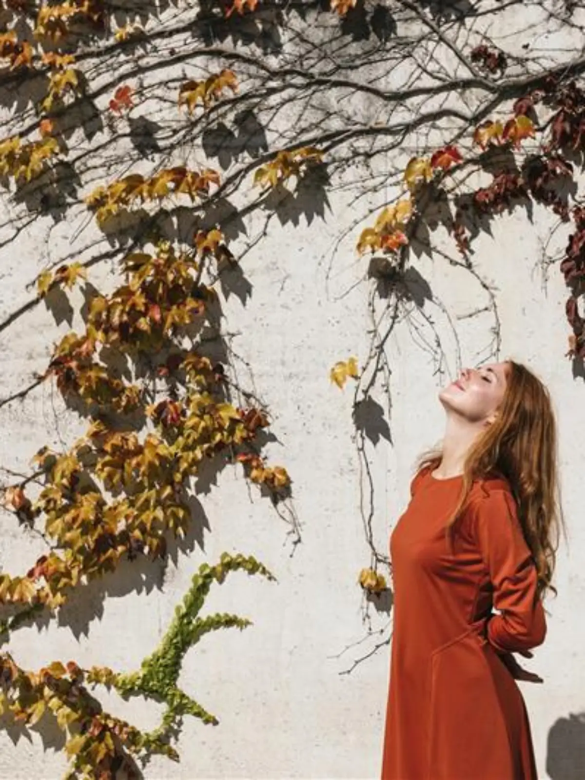 Frau trägt ein orangefarbenes Midikleid im Herbst.