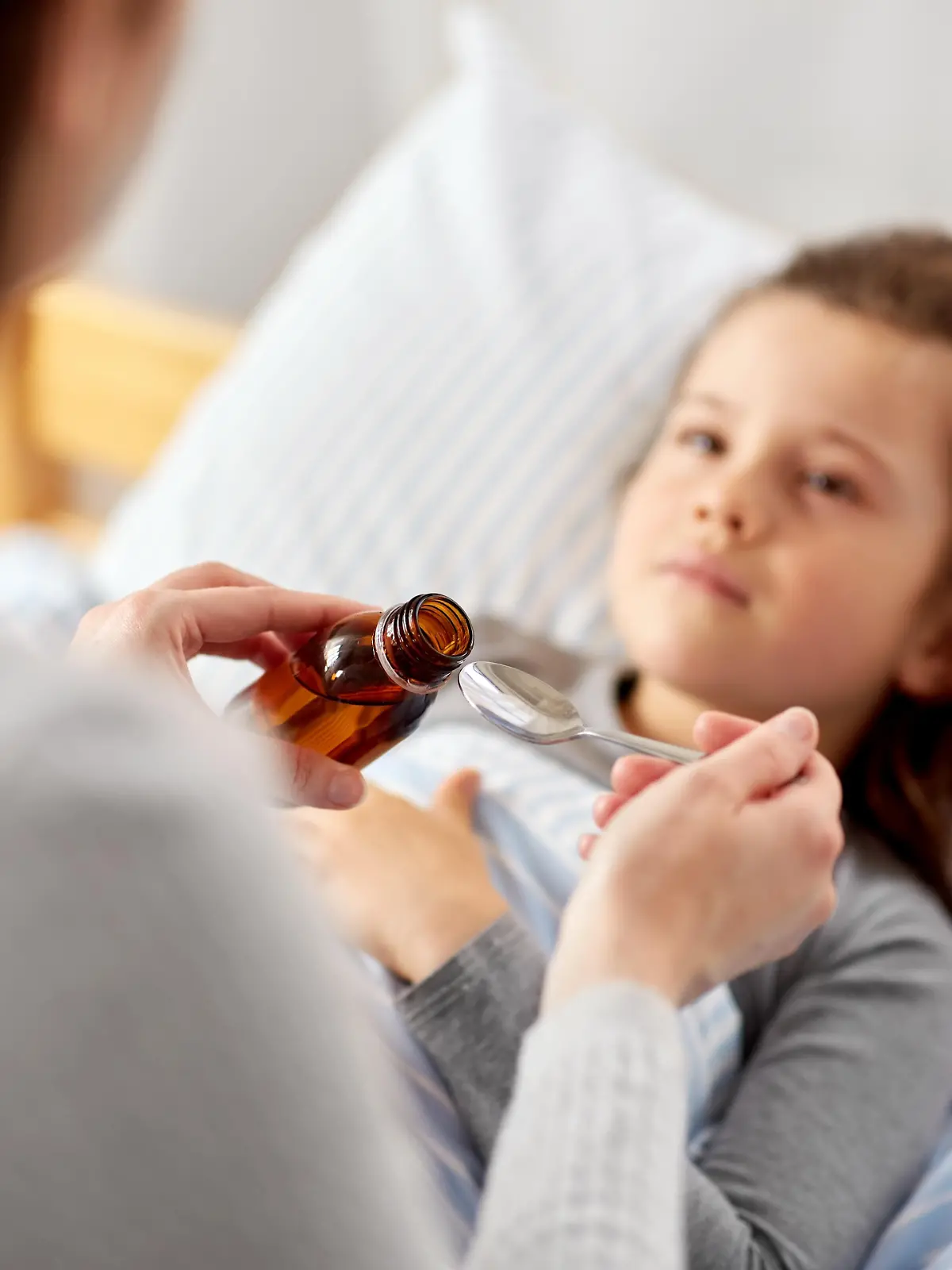 Krankes Kind, Mutter gibt Hustensaft