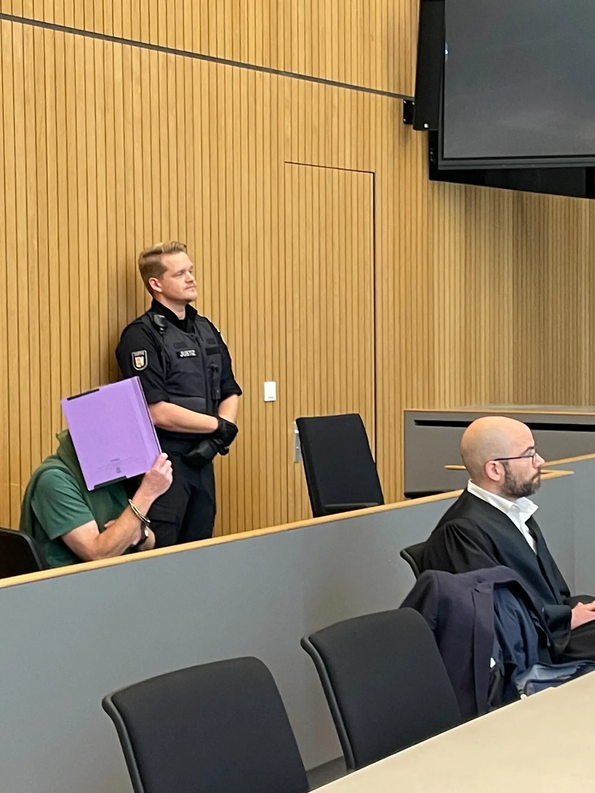 Manfred S., hier im grünen T-Shirt, verdeckt sein Gesicht am Landgericht Lübeck. Laut Staatsanwaltschaft kenne er sich am Fundort der Leiche aus.
