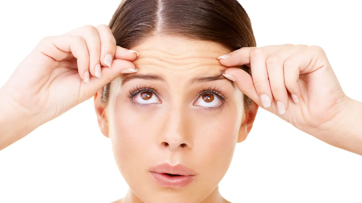 Young brunette pinching her forehead and looking upwards