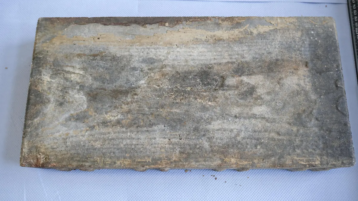 Die Leiche des Jungen war mit einem Stein beschwert. Über den möchte die Polizei mehr wissen. Der 40x20x6 cm große Pflasterstein wird unter dem Markennamen Diephaus, Typ „Natura Vigo“ vertrieben.