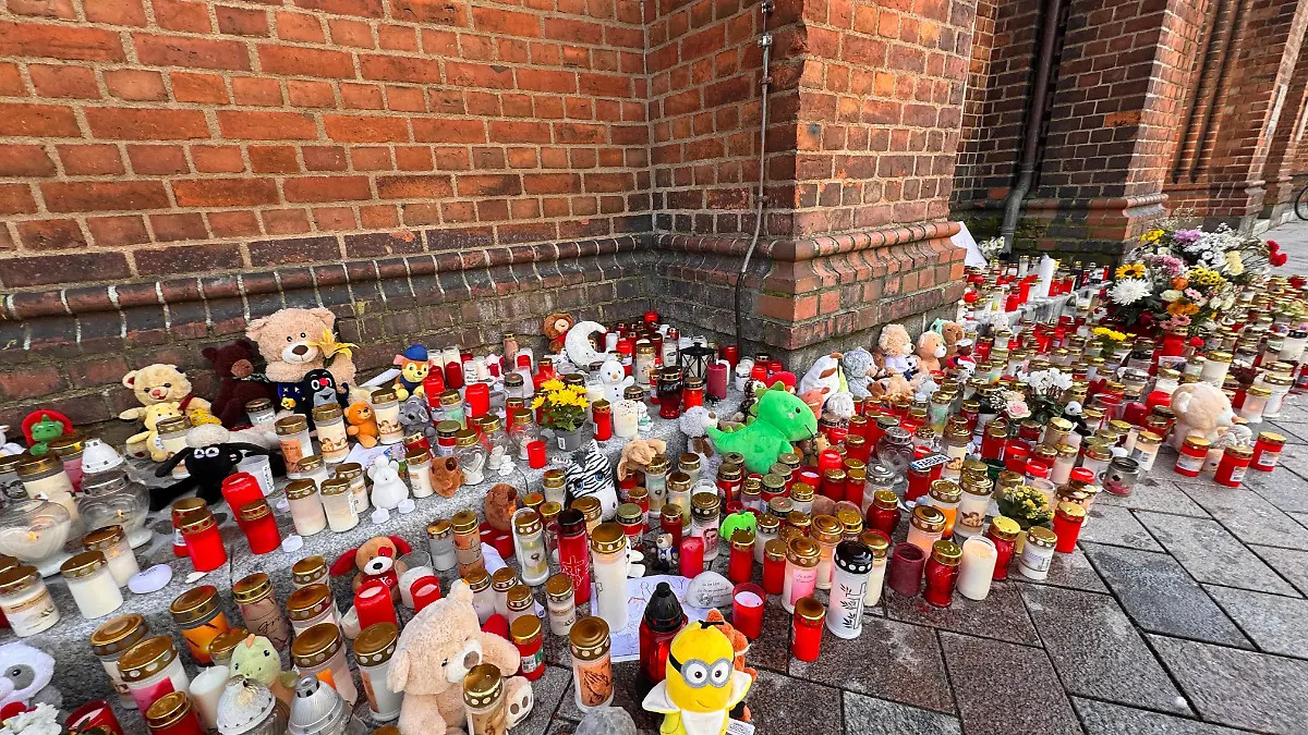 Vor der Pfarrkirche in Güstrow sammeln sich Kerzen und Kuscheltiere