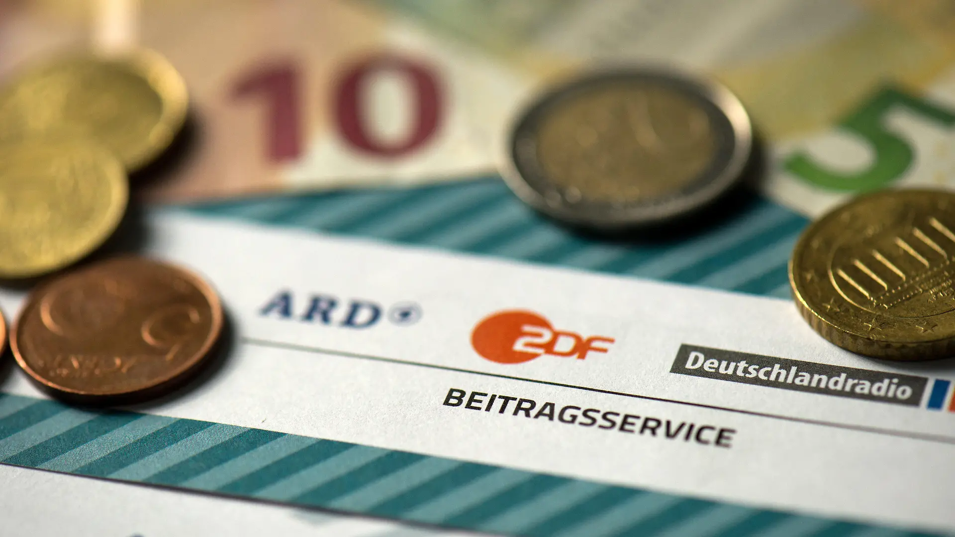ARCHIV - ILLUSTRATION - Münzgeld liegt auf Formularen für den Rundfunkbeitrag von ARD, ZDF und Deutschlandradio am 15.04.2016. (zu dpa Einnahmen aus Rundfunkbeitrag sinken erneut vom 21.06.2017) Foto: Arno Burgi/dpa-Zentralbild/dpa +++(c) dpa - Bildfunk+++