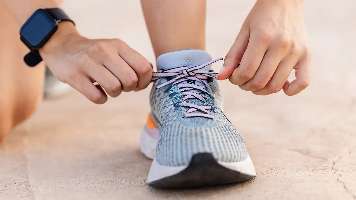 Frau schnürt ihre Laufschuhe zu.