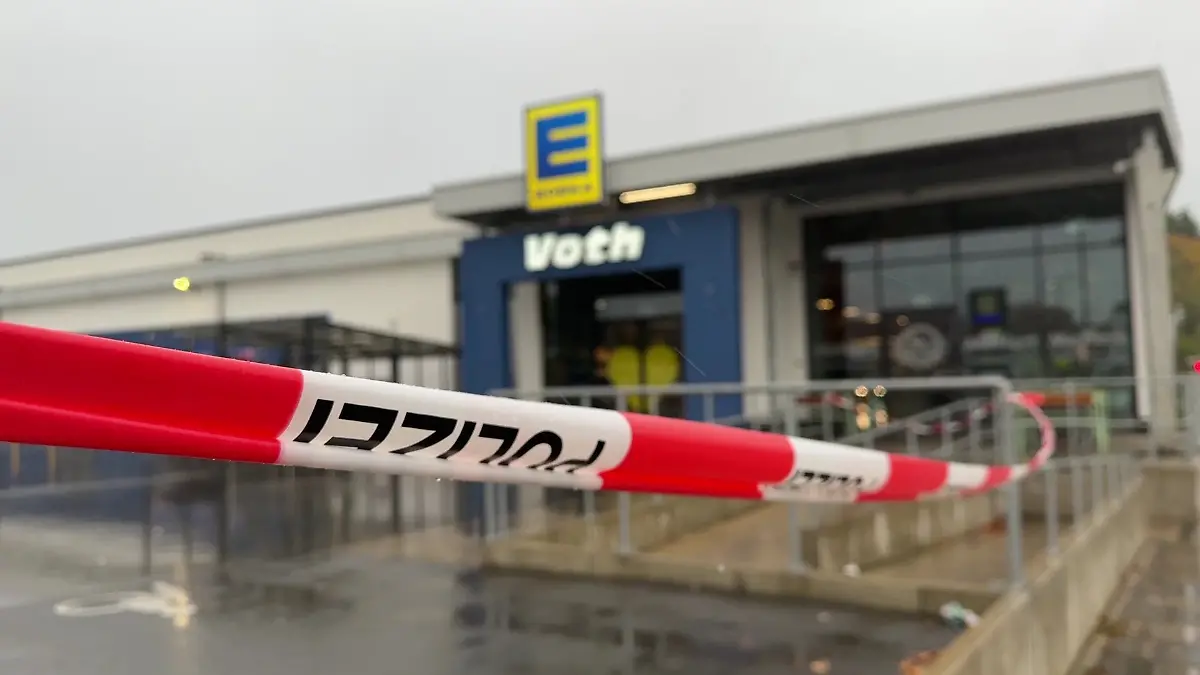 Ein Flatterband der Polizei weht vor dem Edeka in Lemgo