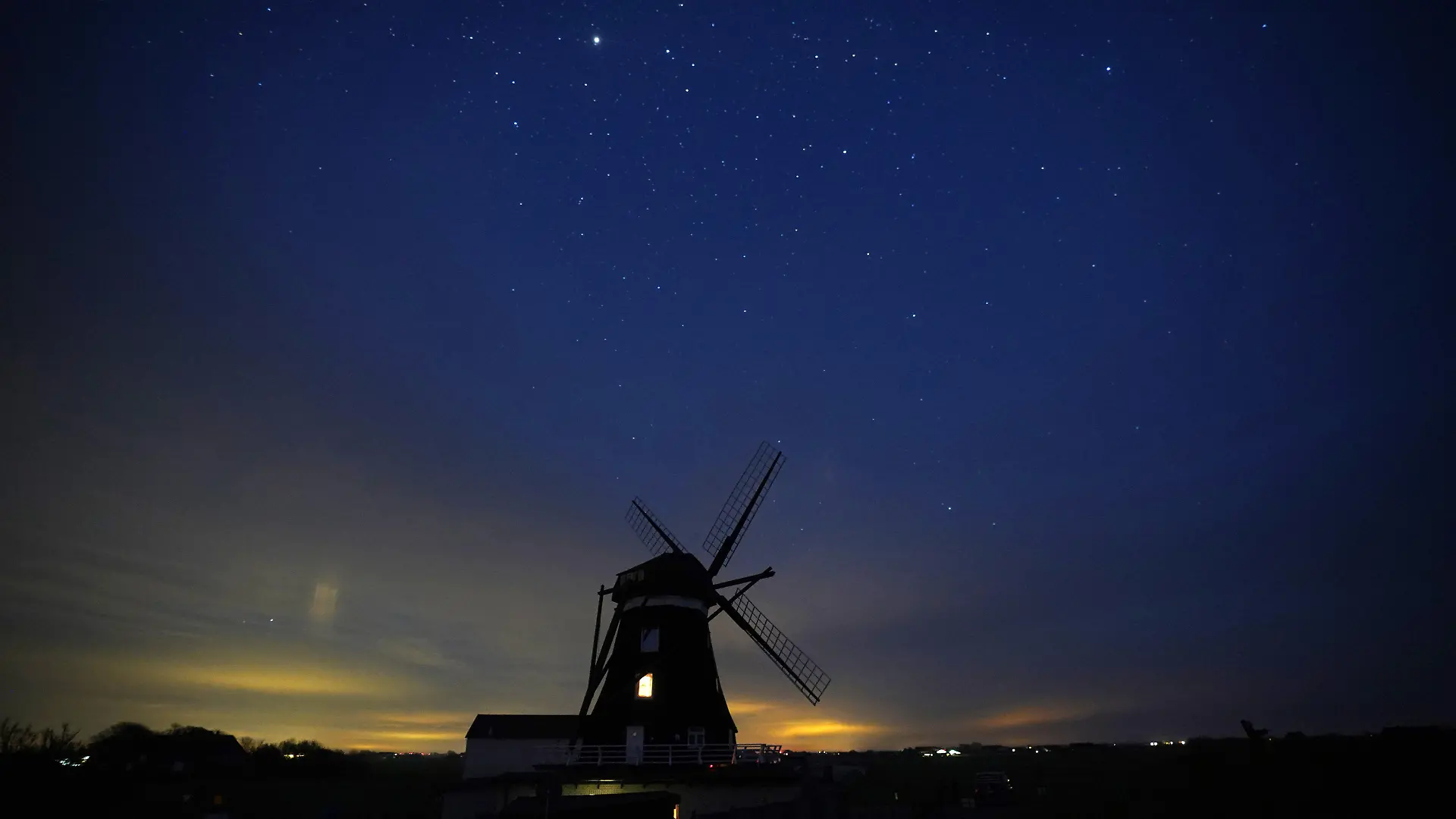 ARCHIV - 10.05.2021, Schleswig-Holstein, Pellworm: Der Sternenhimmel ist über der Nordermühle auf der Insel Pellworm zu sehen. Der natürlich dunkele Sternenhimmel über den Nordseeinseln Spiekeroog und Pellworm zieht zunehmend Sternengucker an.     (zu dpa "Pellworm und Spiekeroog profitieren von «Sterneninsel»-Status") Foto: Marcus Brandt/dpa +++ dpa-Bildfunk +++