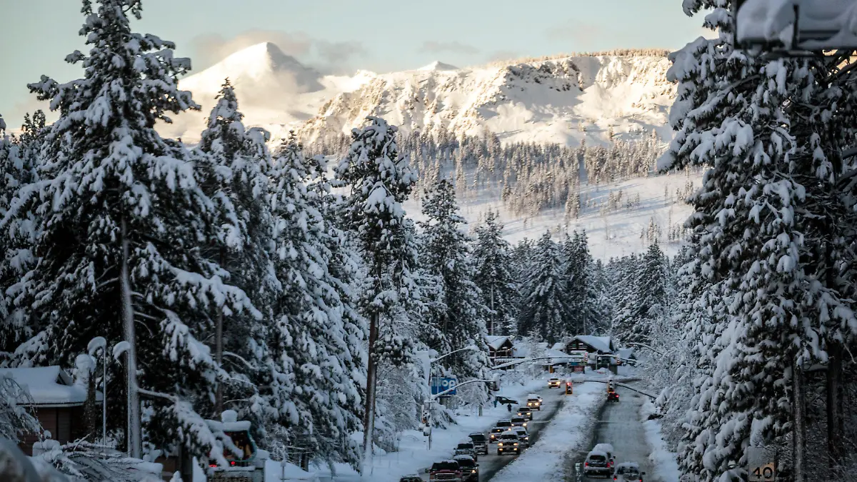 01.01.2023, USA, South Lake Tahoe: Fahrzeuge fahren am Morgen nach einem Wintersturm, der die Region mit einer großen Menge Schnee bedeckte, auf der schneebedeckten U.S. Route 50 in South Lake Tahoe. Foto: Stephen Lam/San Francisco Chronicle/AP/dpa - ACHTUNG: Nur zur redaktionellen Verwendung und nur mit vollständiger Nennung des vorstehenden Credits +++ dpa-Bildfunk +++