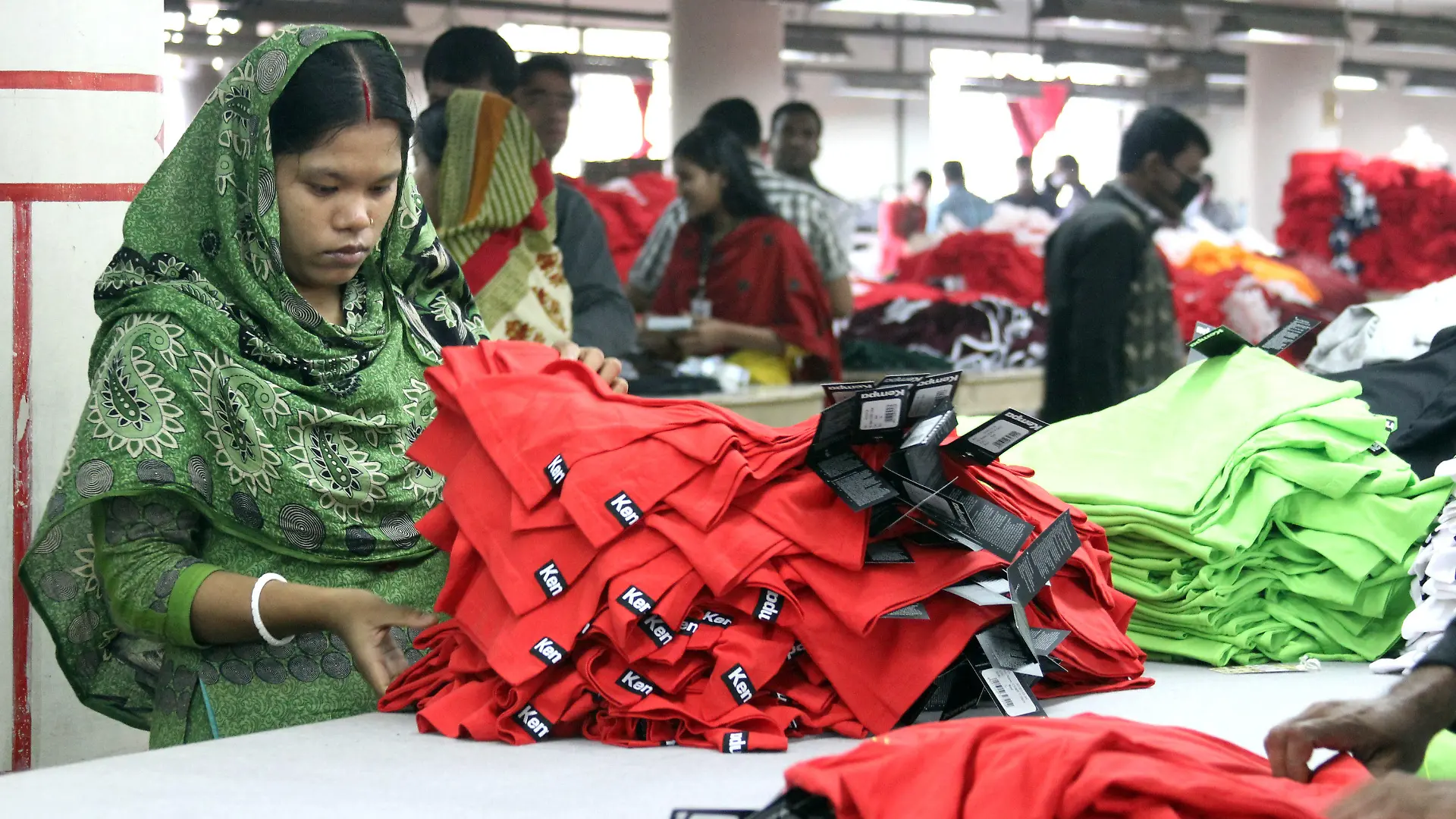 ARCHIV - Frauen und Männer arbeiten am 03.01.2014 in der Textilfabrik "One Composite Mills" in Gazipur, einem Vorort der Hauptstadt Dhaka in Bangladesch. Foto: Doreen Fiedler/dpa (zu dpa "Umfrage: Verbraucher wollen bei Kleidung fair und billig zugleich" vom 12.08.2014) +++(c) dpa - Bildfunk+++