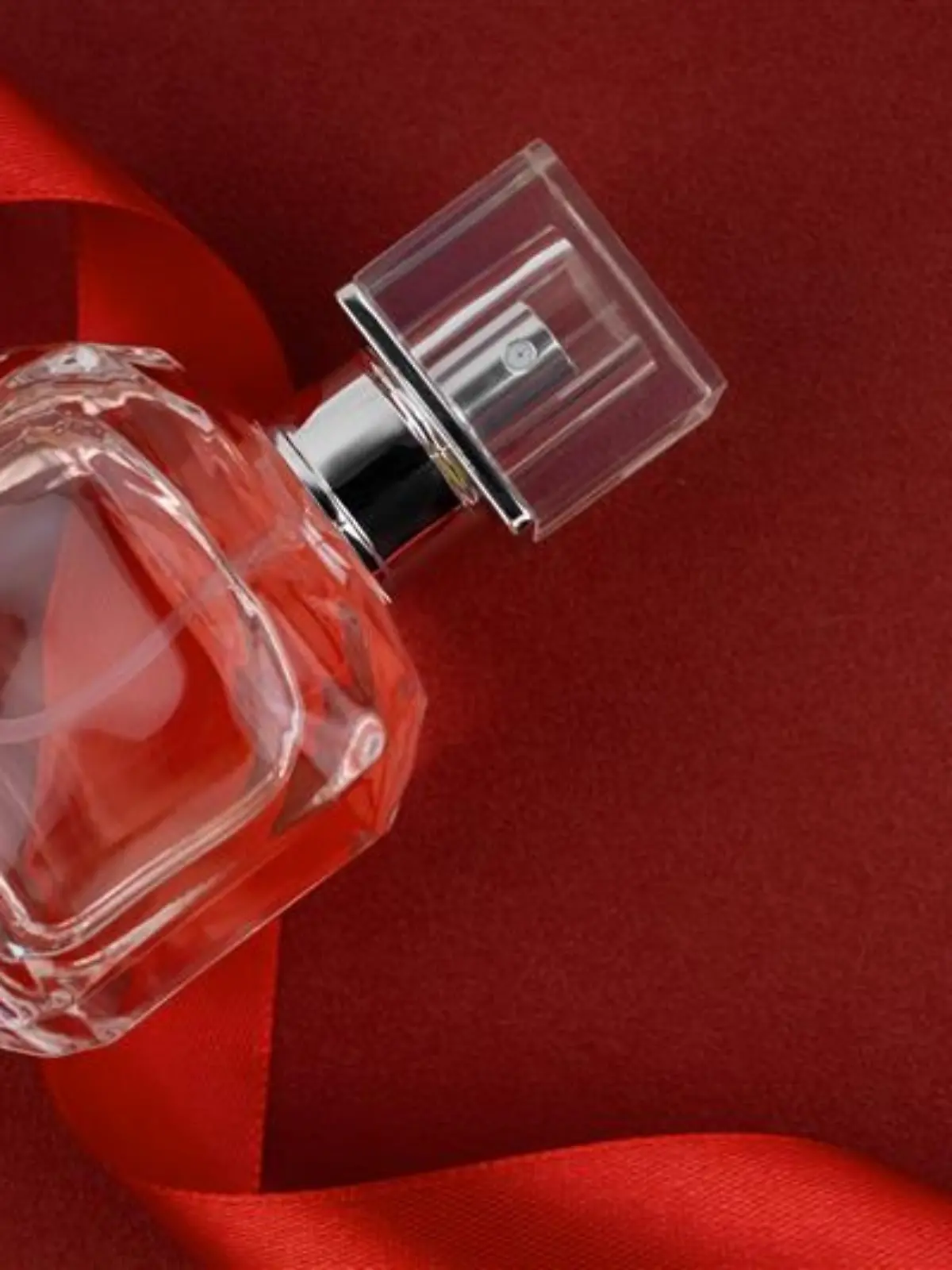 Parfumflakon vor rotem Hintergrund.