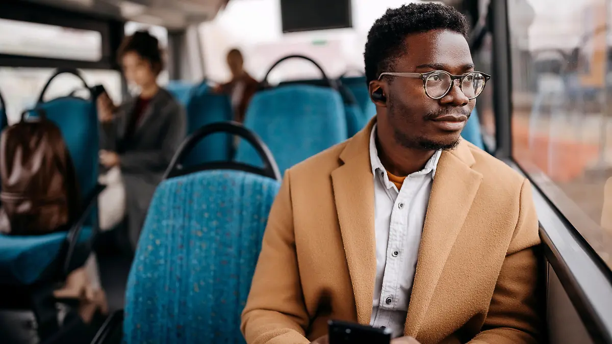 Young handsome man on public bus using mobile phone