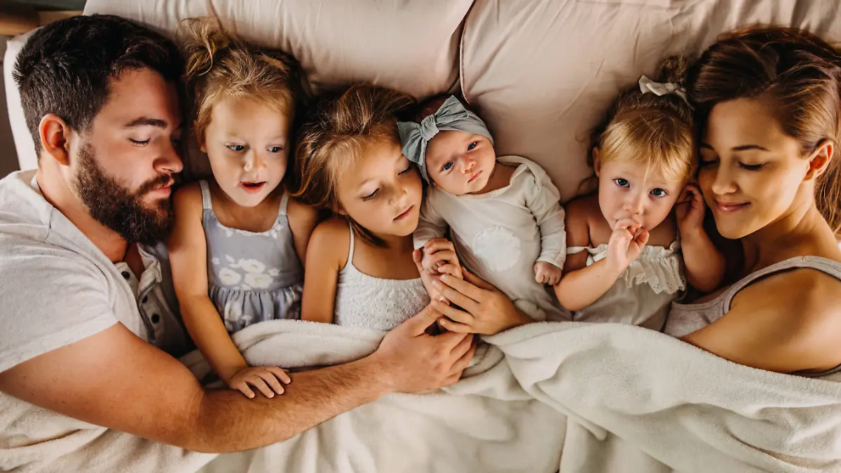 Familie, die im Bett liegt und kuschelt
