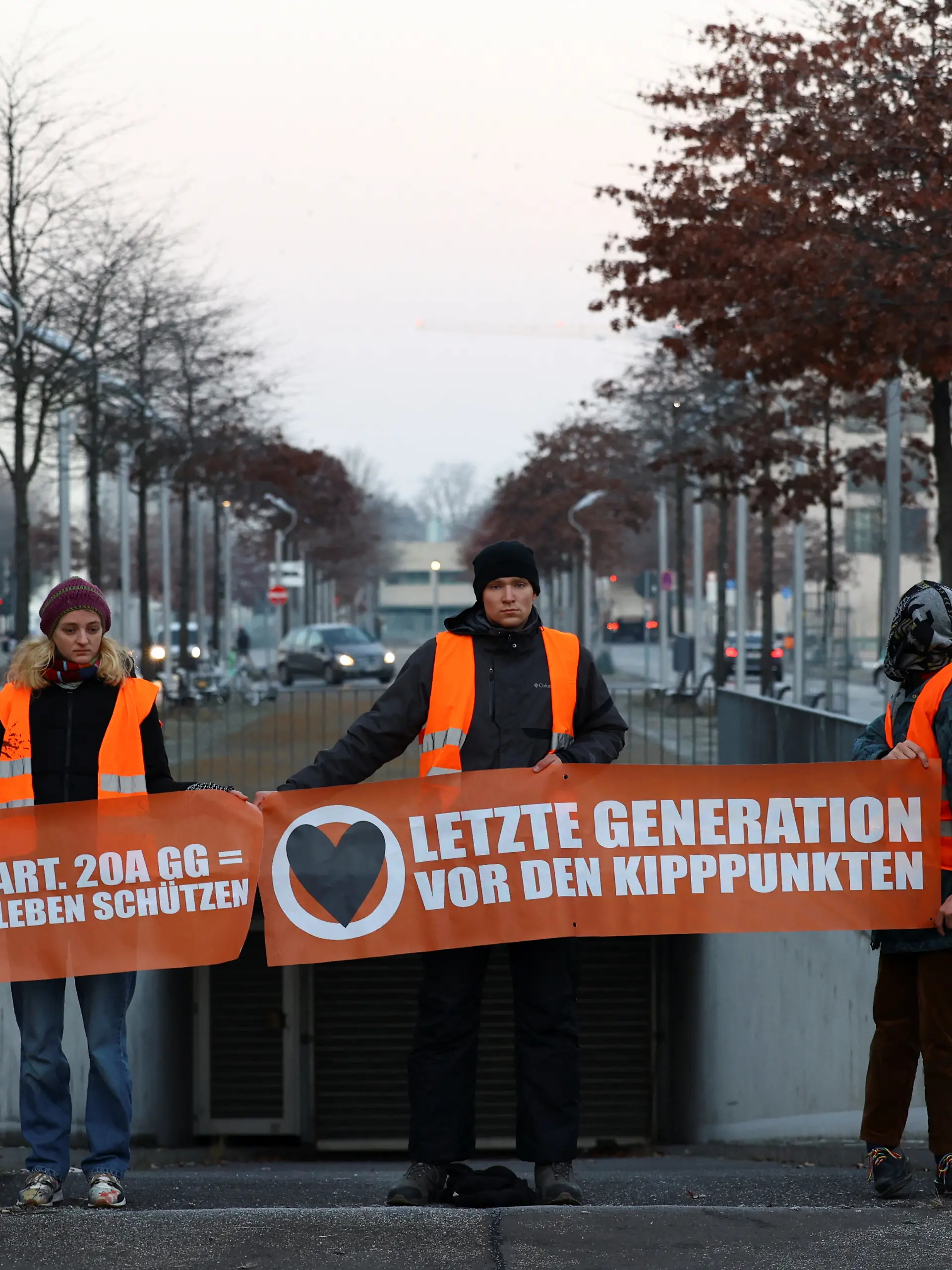 Activists of "Letzte Generation" (Last Generation) hold a banner at the entrance of the parking garage of Germany's lower house of parliament Bundestag to protest for a speed limit on highways as well as for affordable public transport, in Berlin, Germany December 15, 2022. REUTERS/Christian Mang