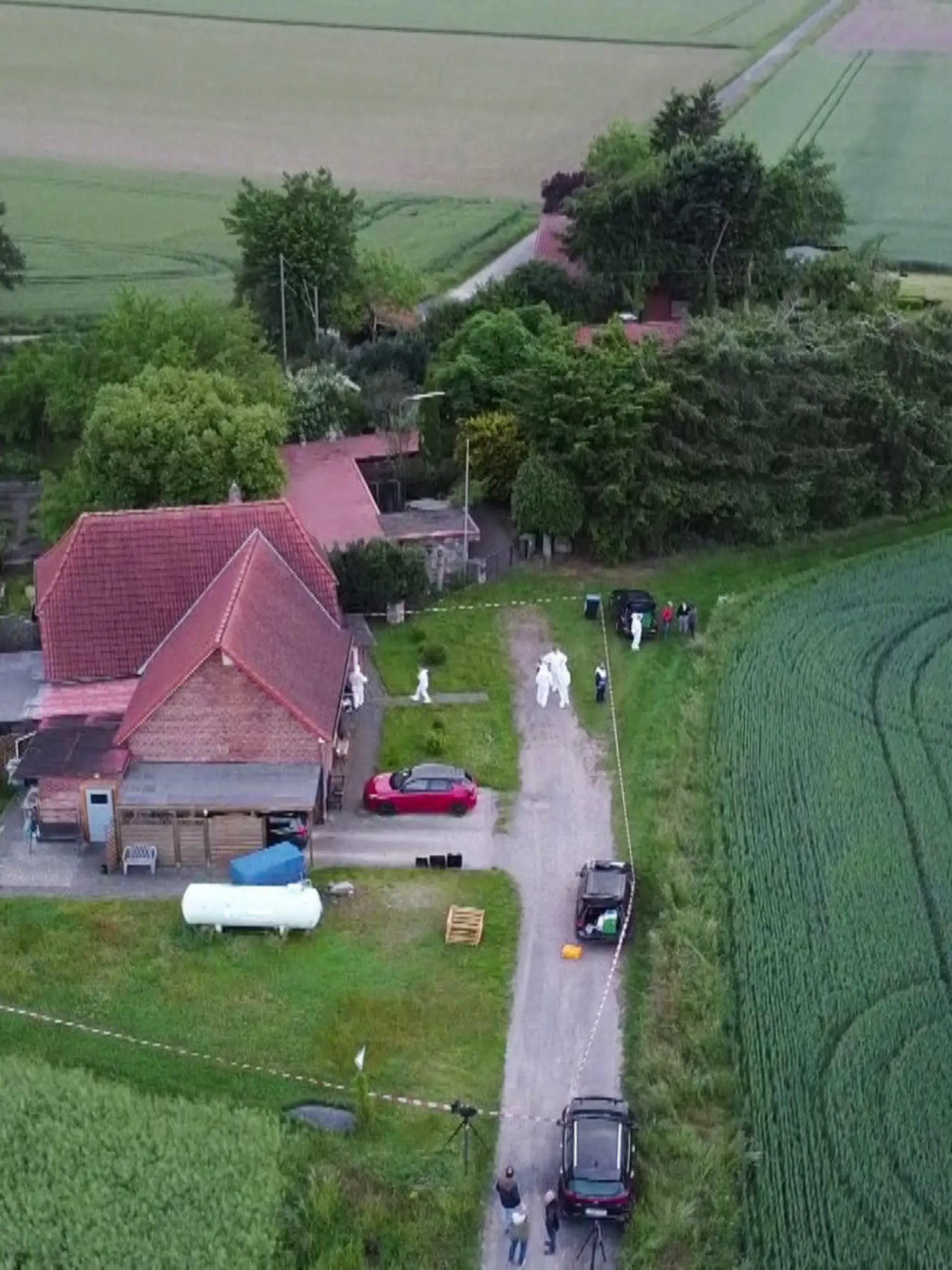 30.05.2022, Niedersachsen, Neustadt am Rübenberge: Ein Polizeiabsperrband ist um ein Haus gespannt, vor dem Menschen in Schutzanzügen stehen. In einem abgelegenen Haus in Neustadt am Rübenberge bei Hannover sind am Montag zwei tote Menschen entdeckt worden. Foto: -/TNN/dpa +++ dpa-Bildfunk +++