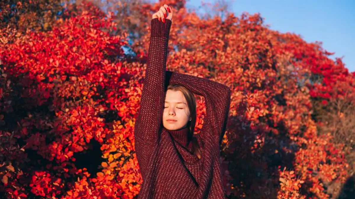 Frau trägt einen Pullover in Beerenrot.