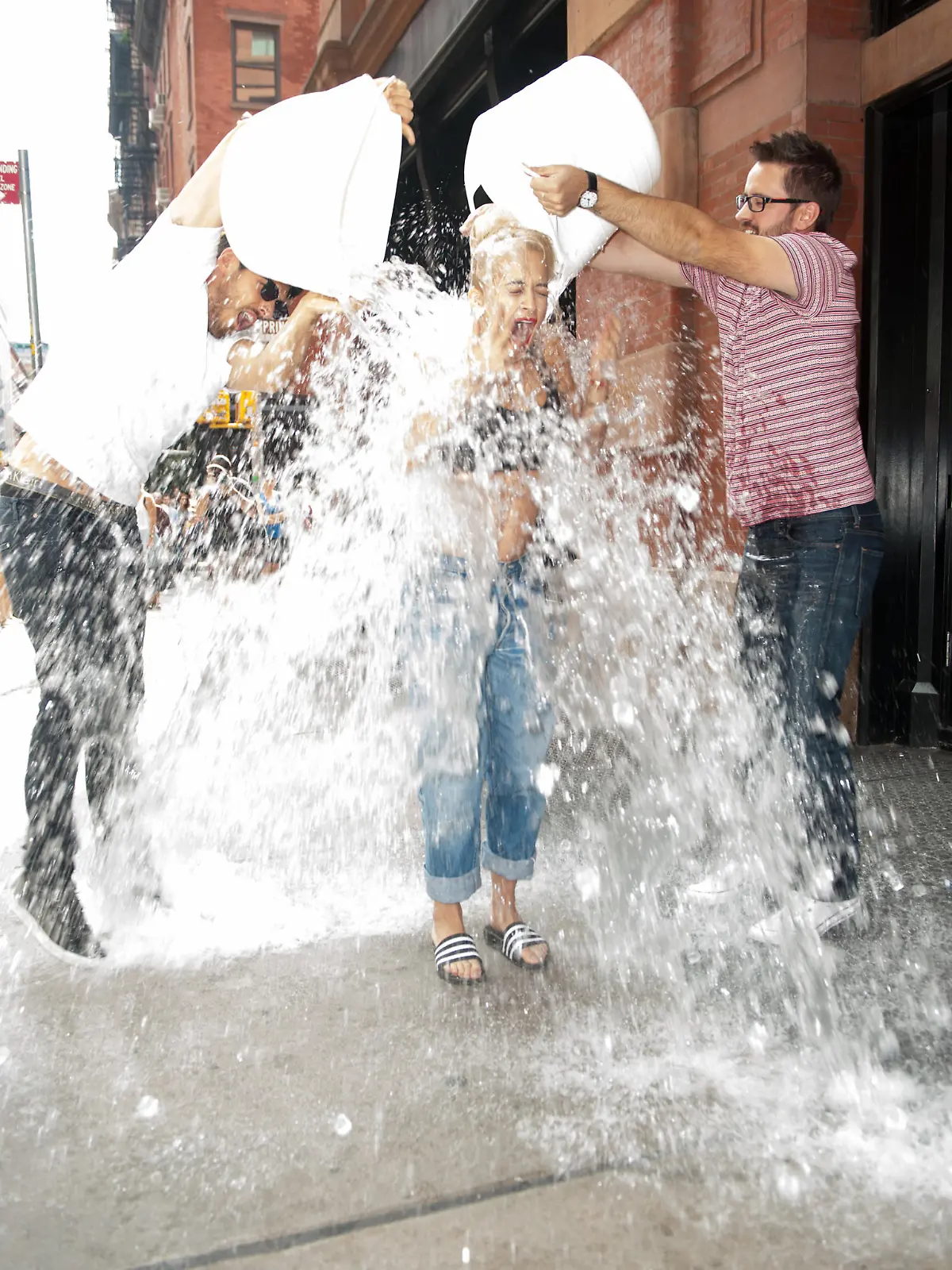 Rita Ora completes the ALS ICE Bucket challenge out side her NYC Hotel and challenges Iggy Azalea to do the challenge next.  