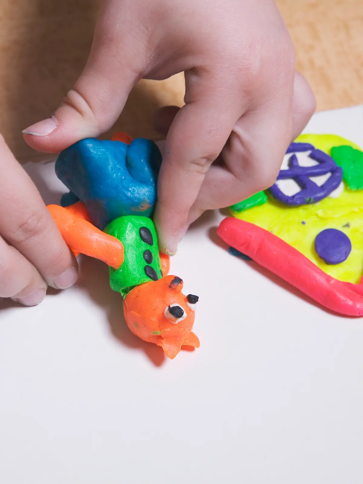 Kinderhände, die mit bunter Knetmasse spielen